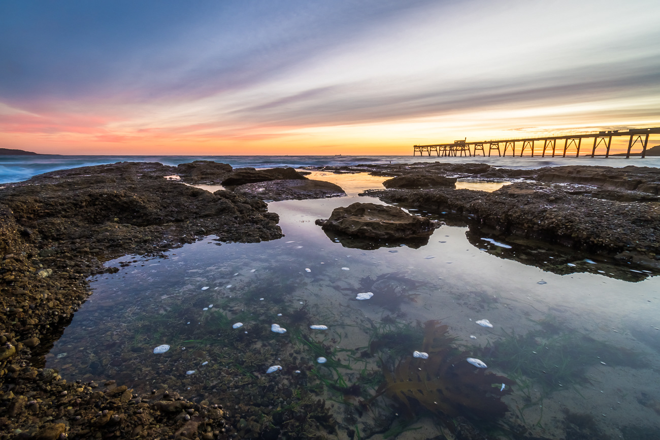 Calming Rock Pools - Catherine Hill Bay NSW Australia.  Calm rock pool with lovely sunrise colour on the horizon - Image taken 12-2-21