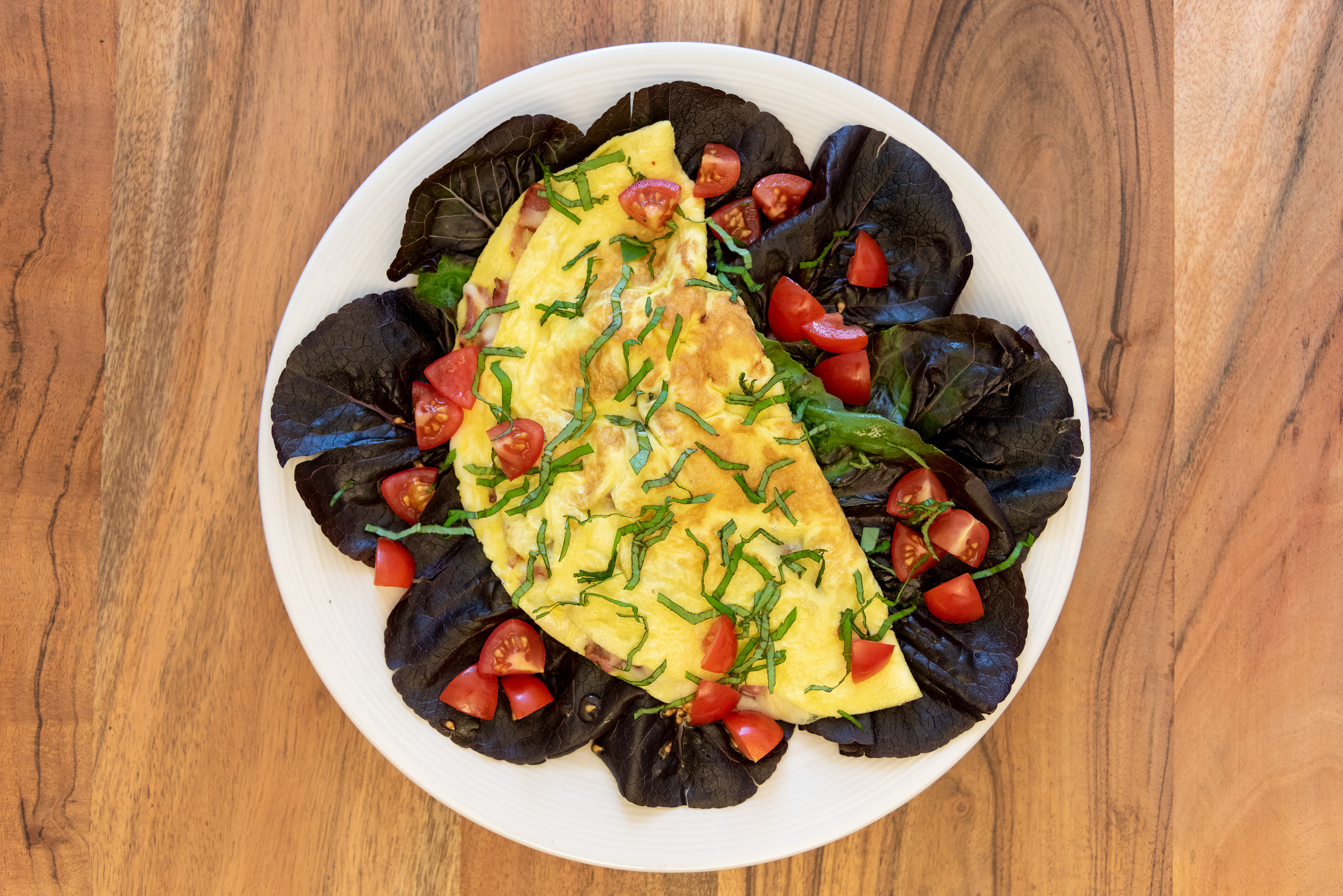 keto low carb dish omelette with salad leafs tomato basil on plate