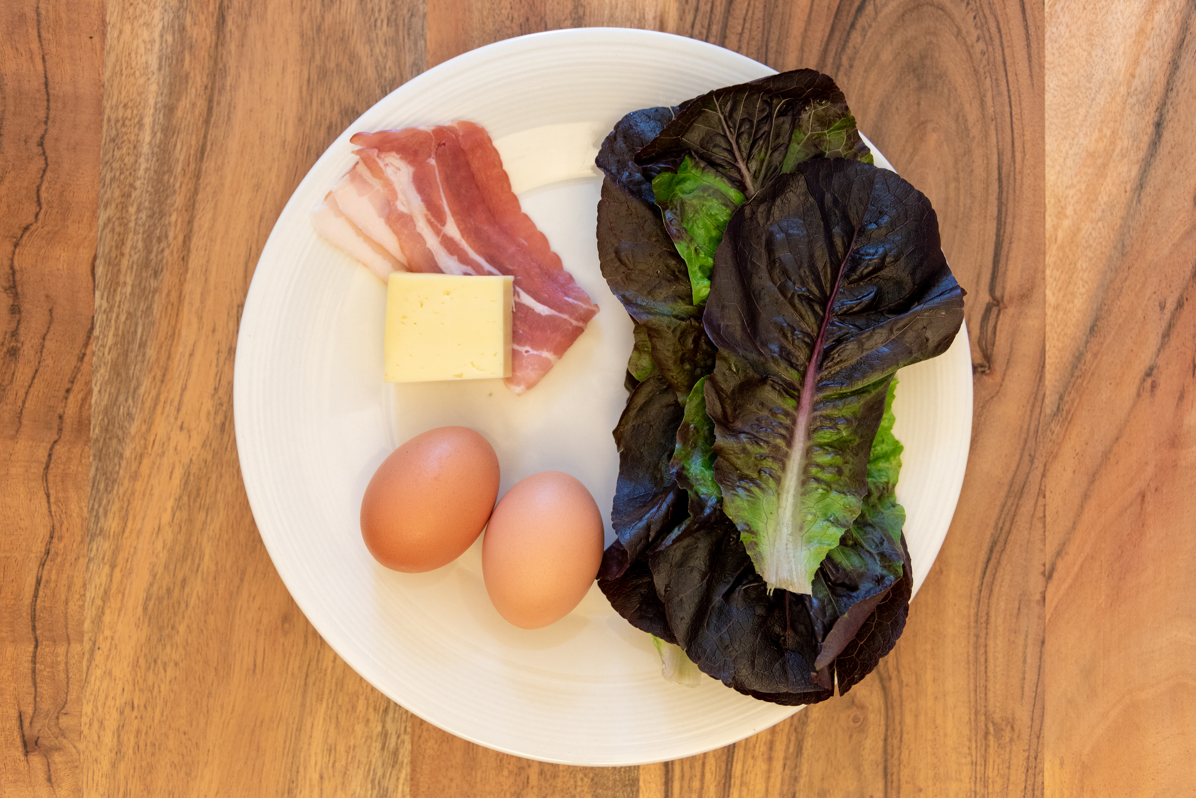 bacon cheese eggs salad ingredients laid out on white plate recipe