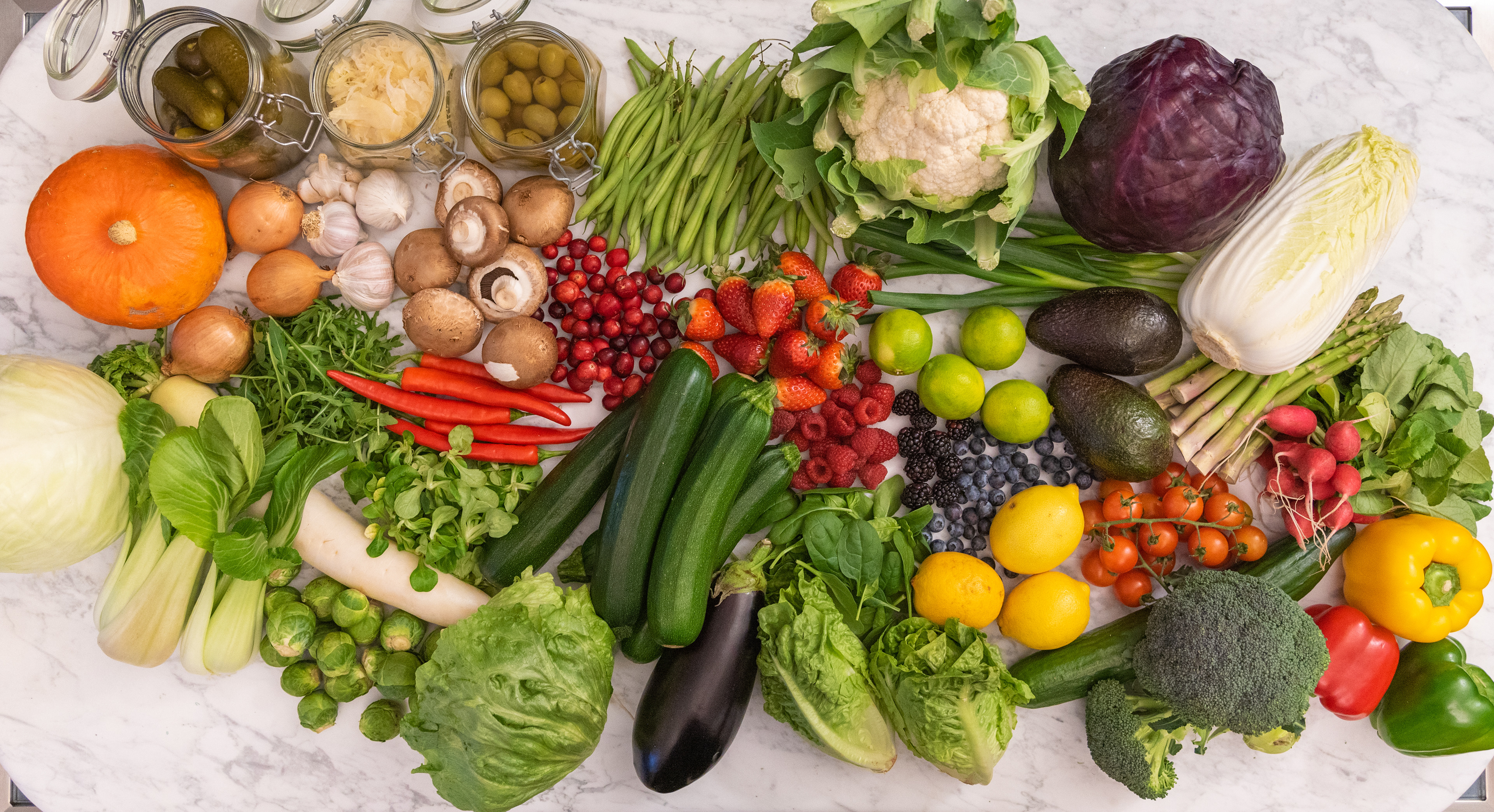 keto low carb high fat paleo vegetables and fruit selection on white marble table top view