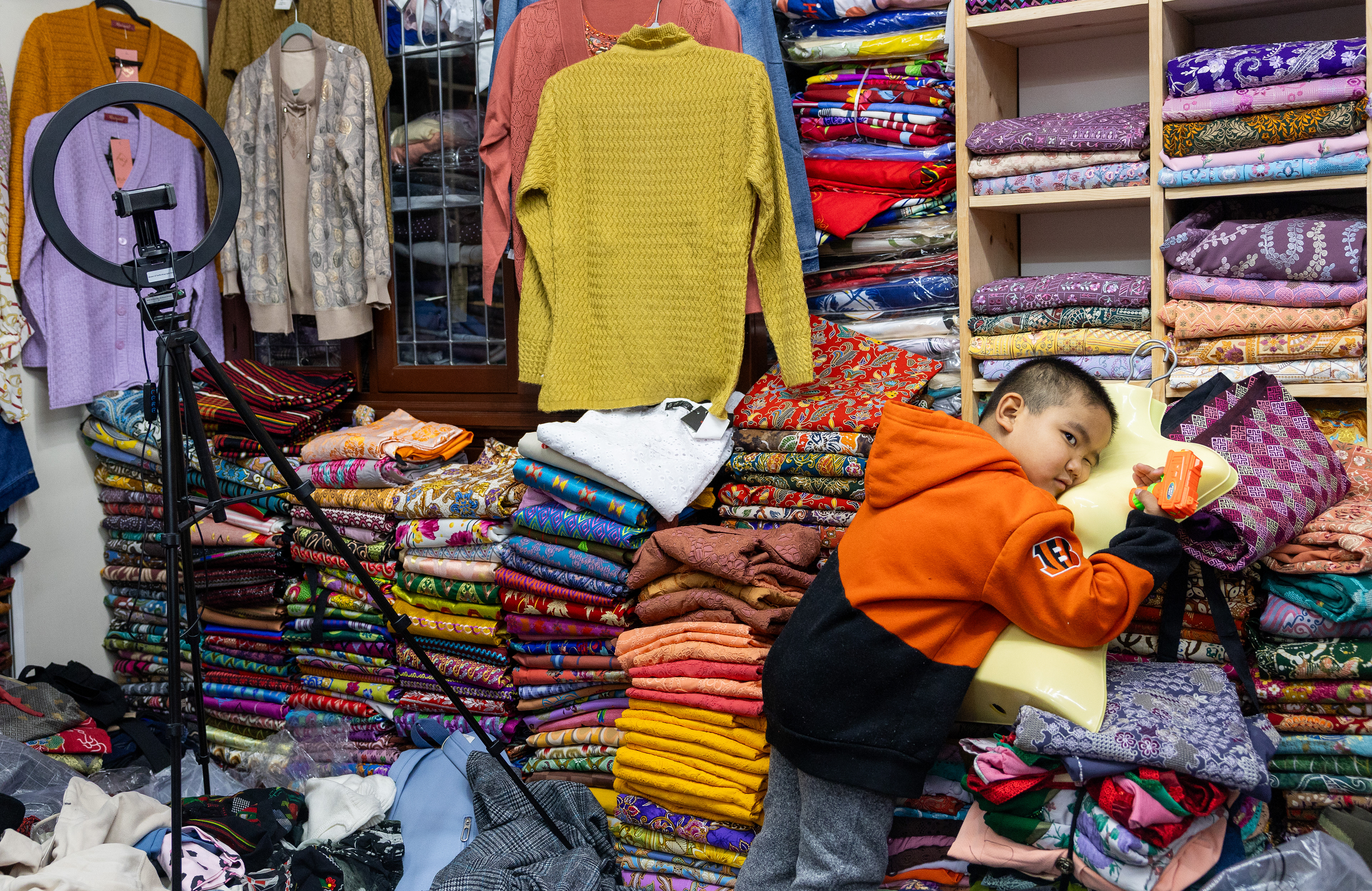 Mang Sian, 5, waits for his mother in a small Burmese clothing store in Bowling Green, Ky., on Wednesday, Feb. 7, 2026, as his mother, Cing Siang, picks out clothing for a friend who supported her after the recent loss of her husband, Sian’s father. “He is too young to understand that his dad is gone,” Siang said.