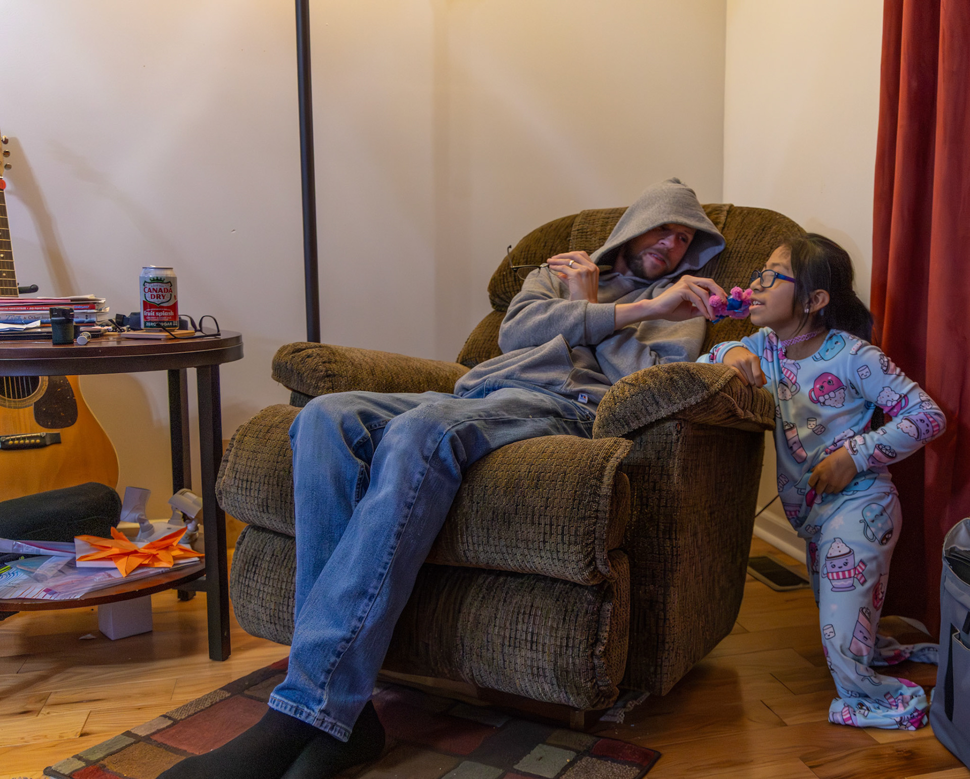 Gabi's adoptive father Travis Bilbrey pretends to give her a kiss on the cheek with a new stuffed pig she crafted in their Bowling Green home on Dec. 1, 2025.