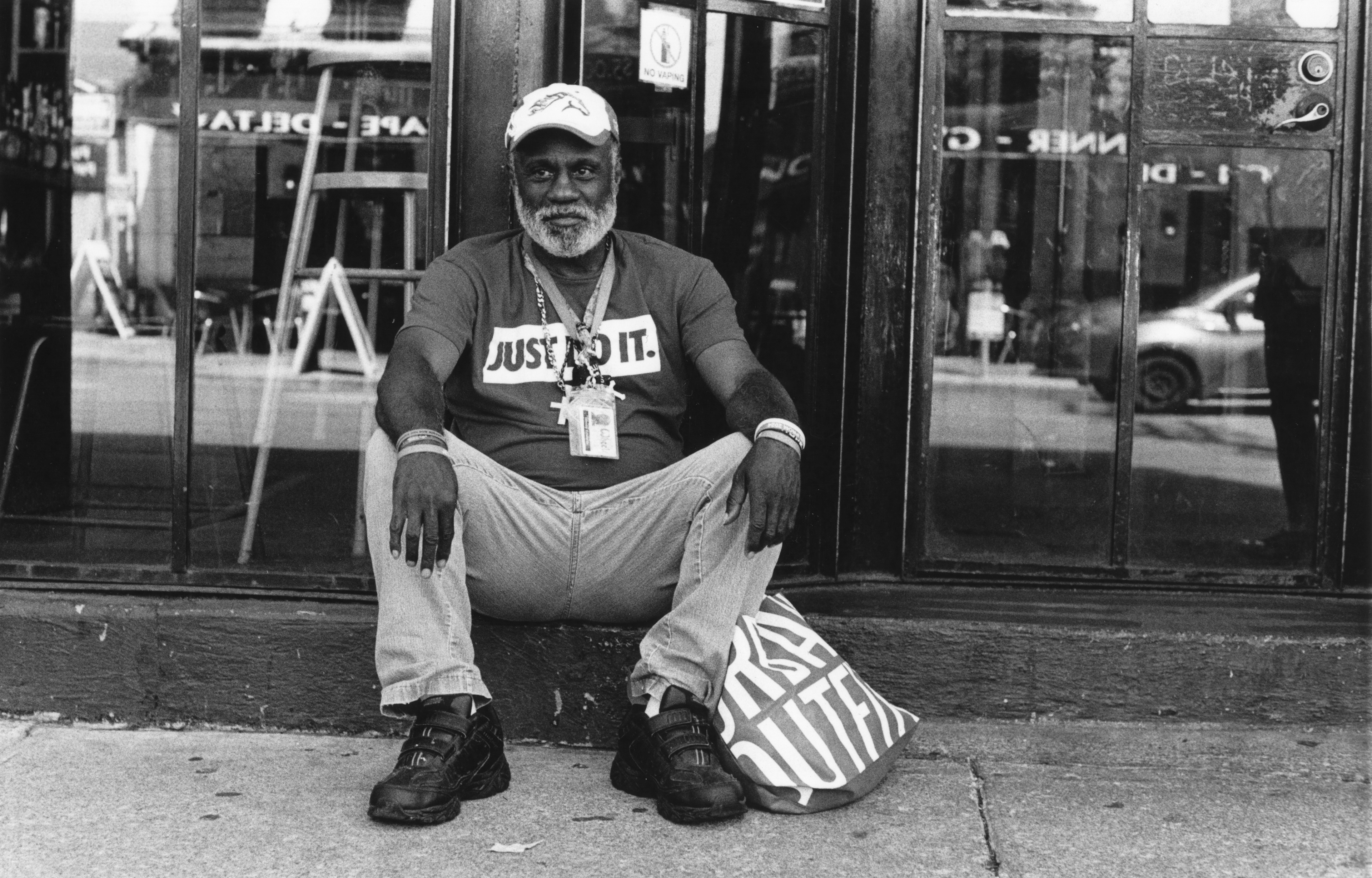 A man sits on a curb listening to music in downtown Lexington, Kentucky., Tuesday, June 18, 2024.