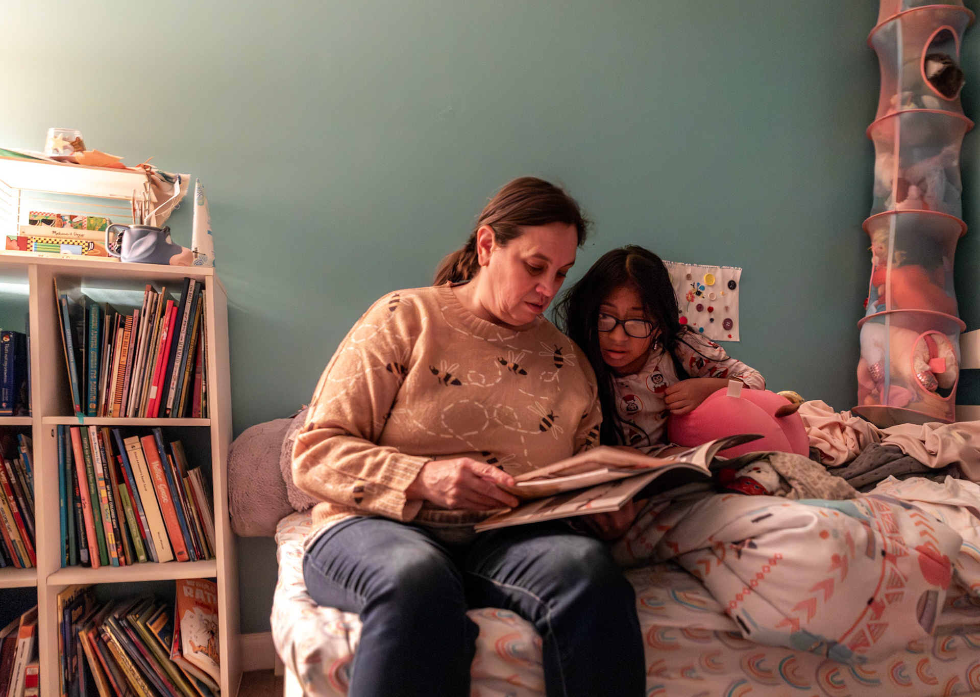 Gabi's mother Betsy Bilbrey reads a bedtime story to her daughter in their home on Dec. 9, 2025. Betsy maintains this nightly routine to soothe Gabi before sleep, a quiet moment of connection at the end of each day.