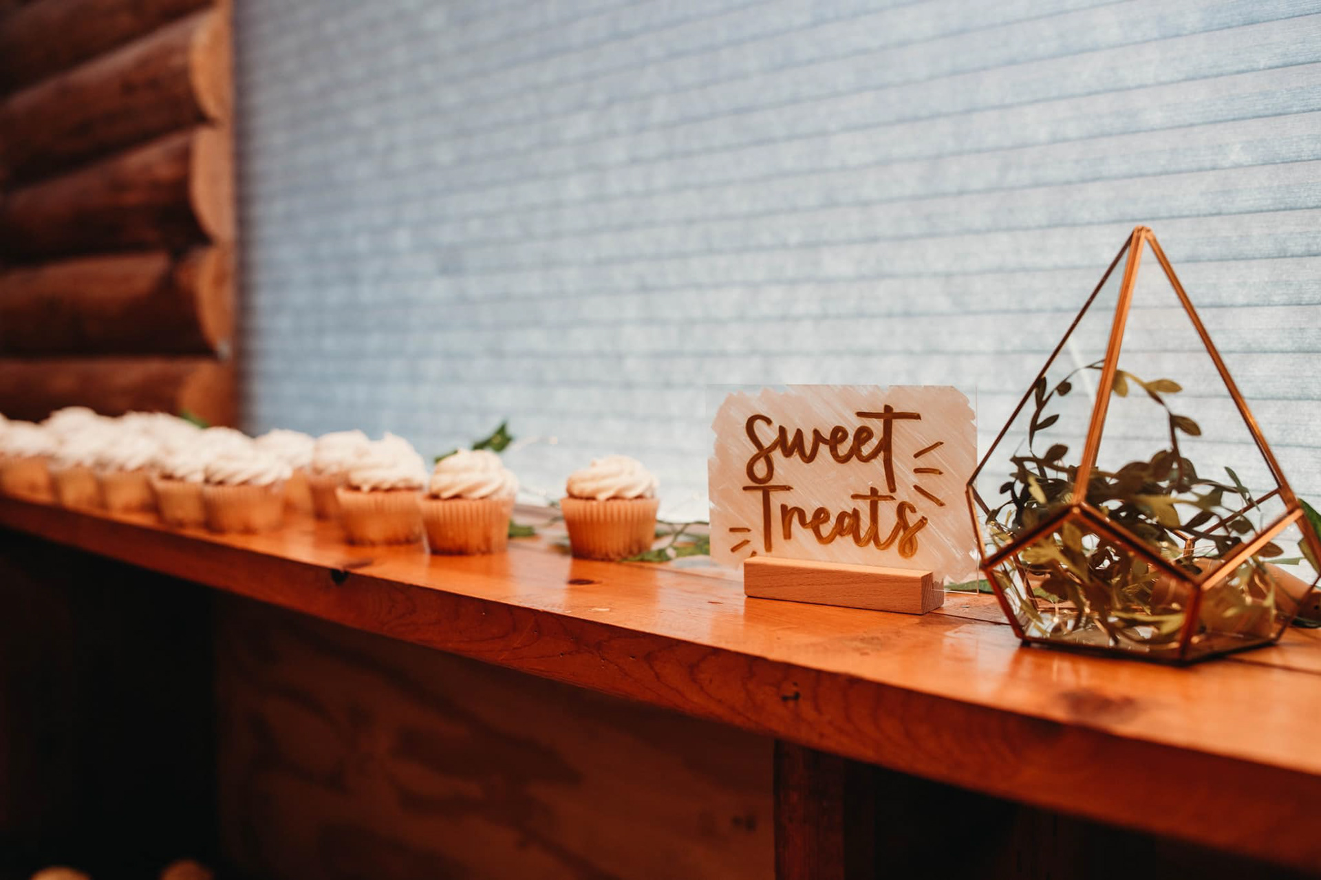 Cupcakes scattered along a window ledge next to a sign that reads 'Sweet Treats.'