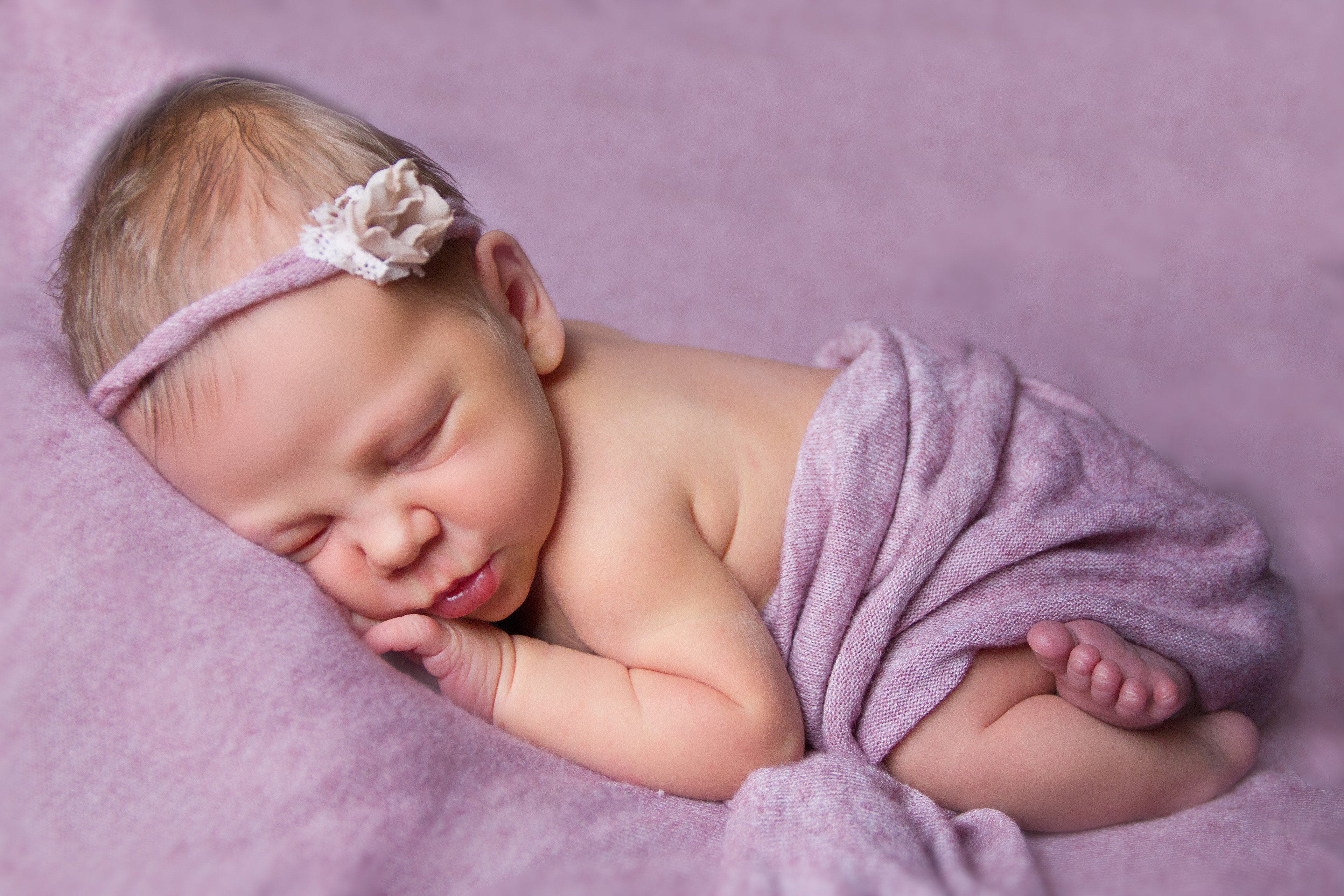 Newborn baby op buikje geposeerd