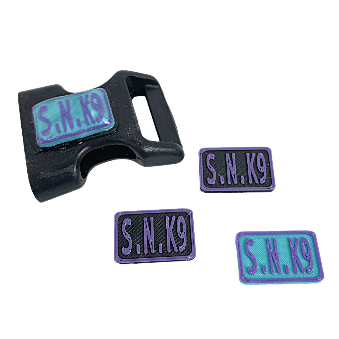 Logo plates for Buckles seen with an early attempt at a UV resin lens.