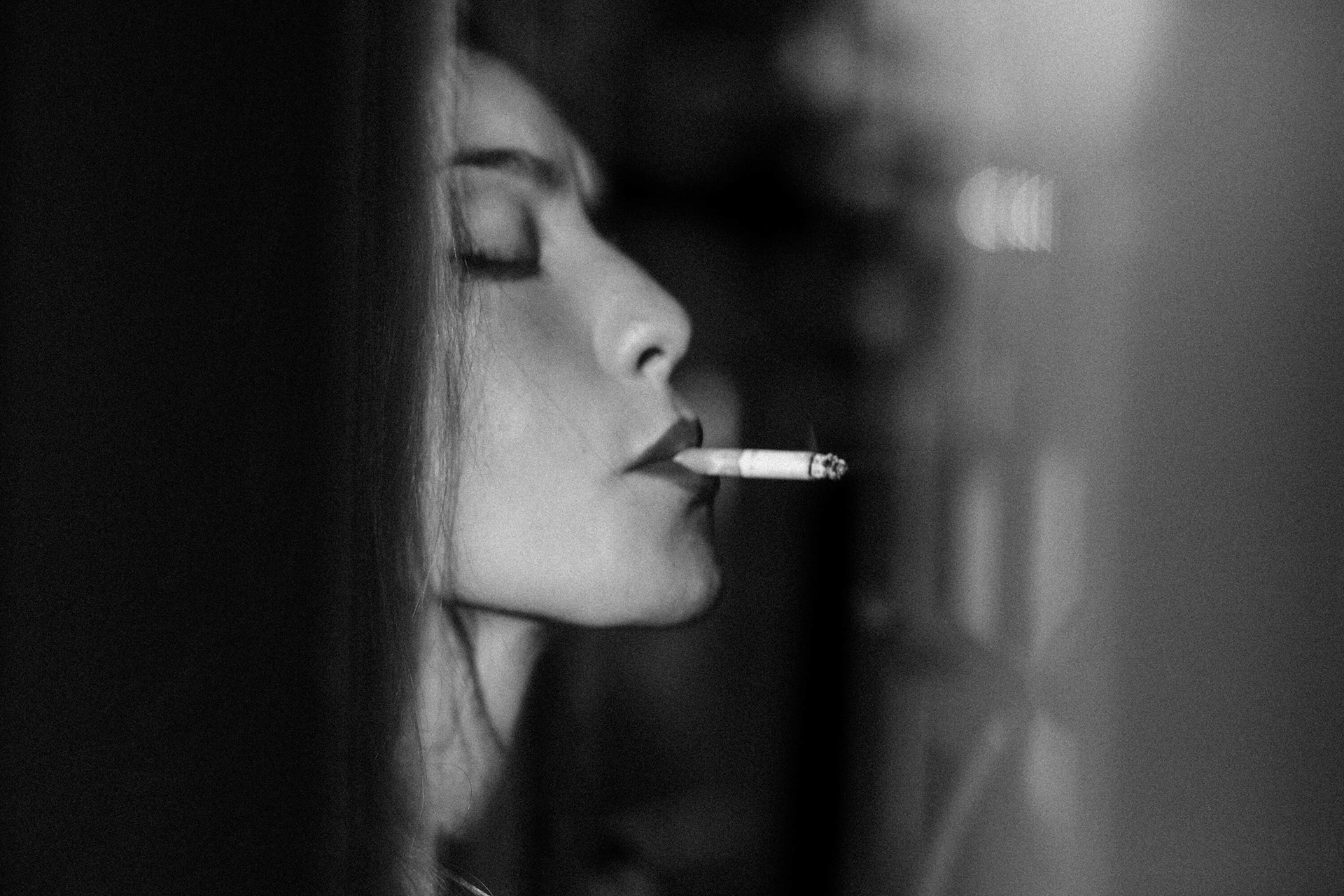 Fine art portrait of a woman smoking a cigarette, captured in soft natural light