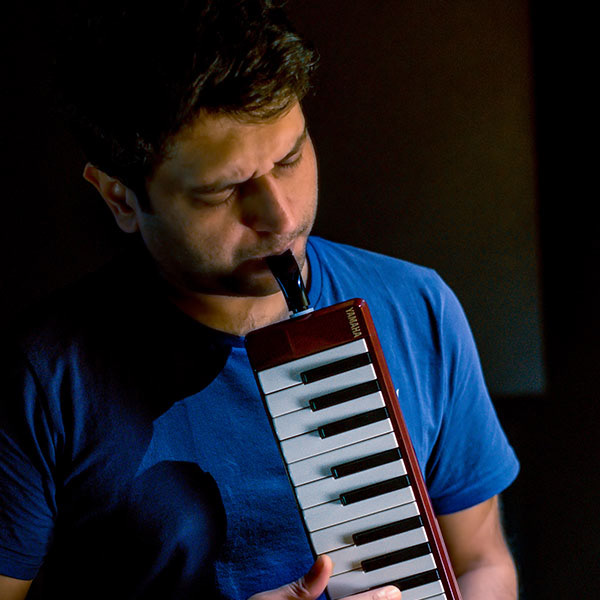 Musician playing mouth piano – creative instrument-based artist branding photoshoot