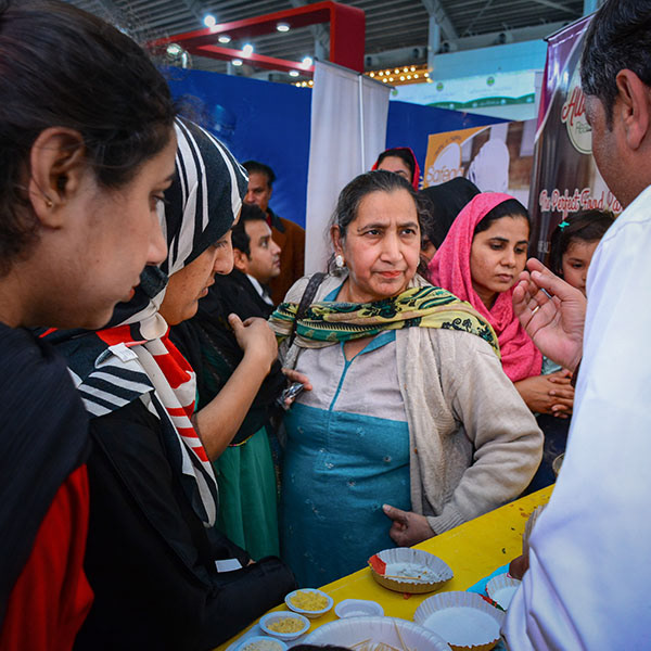 Customers engaging with exhibitor at product stall – trade show photography in Pakistan