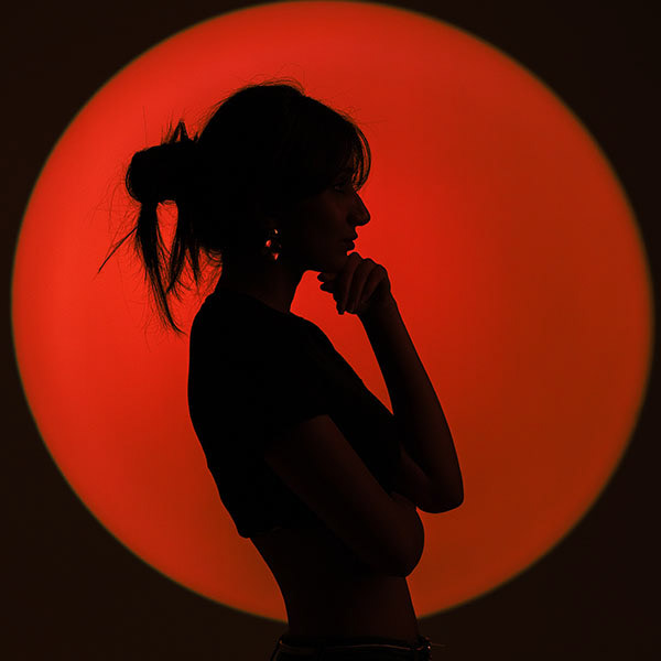 Artistic silhouette of a model striking a pose at sunset, highlighting lifestyle photography with dramatic contrast