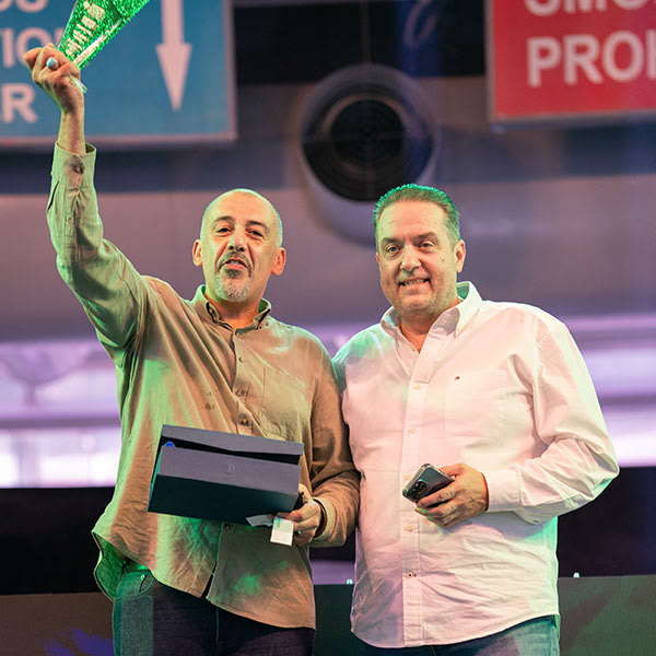 Award ceremony at business expo – two participants showcasing achievement on stage