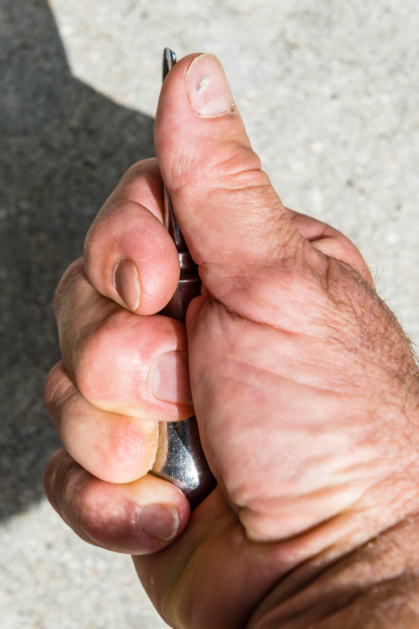 Thumb and elevator tip facing up, open side of fist.