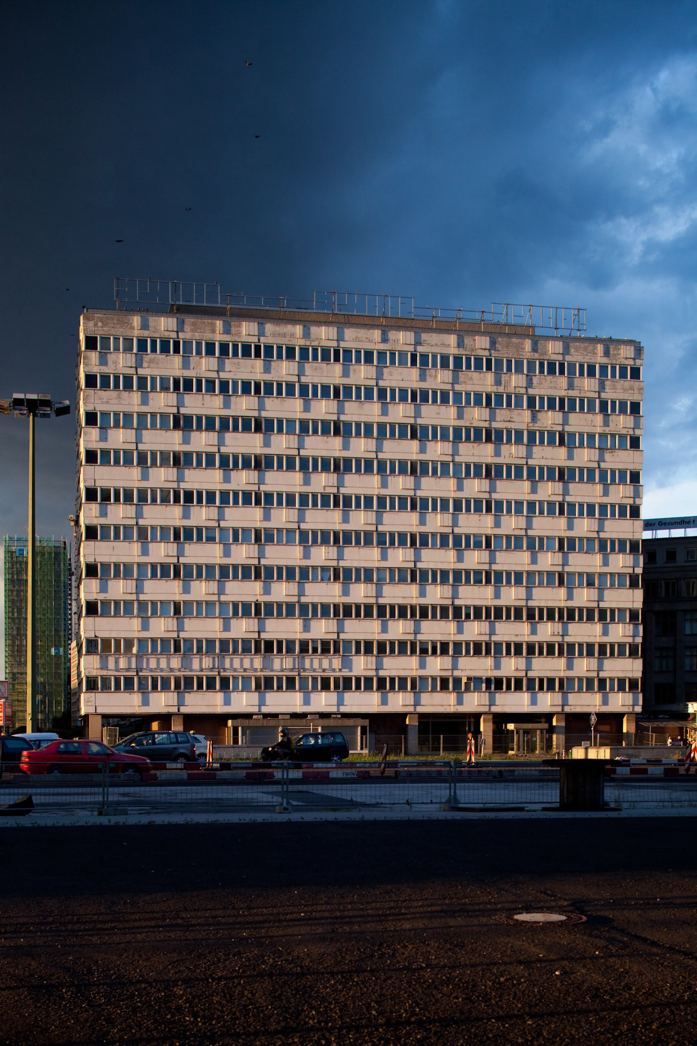 The distinctive apartment building on Karl-Marx-Allee stands tall in East Berlin, reflecting the changing light before a storm.