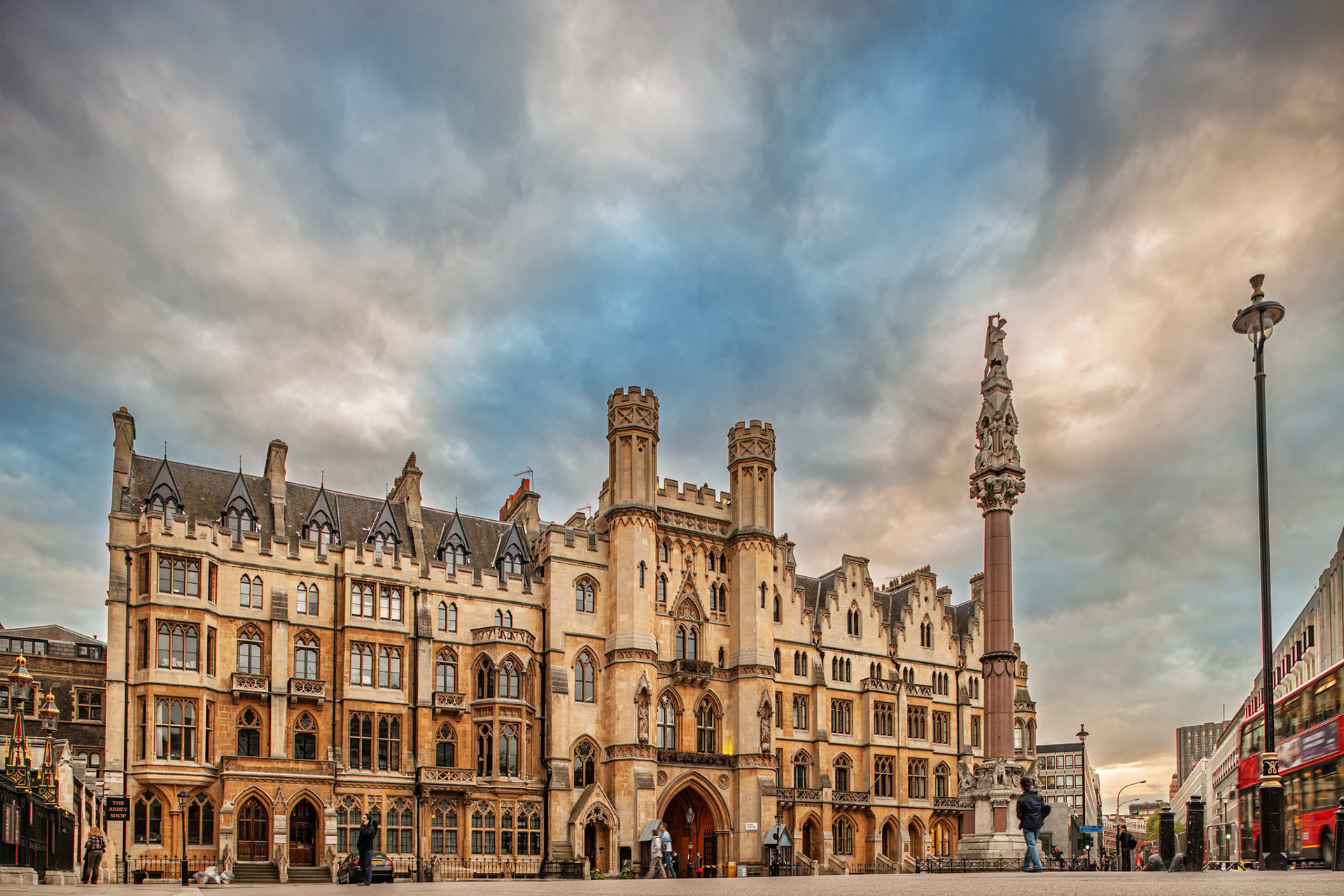 The Broad Sanctuary building stands tall in Westminster, London with historical architecture under a cloudy sky. People walk around the area.