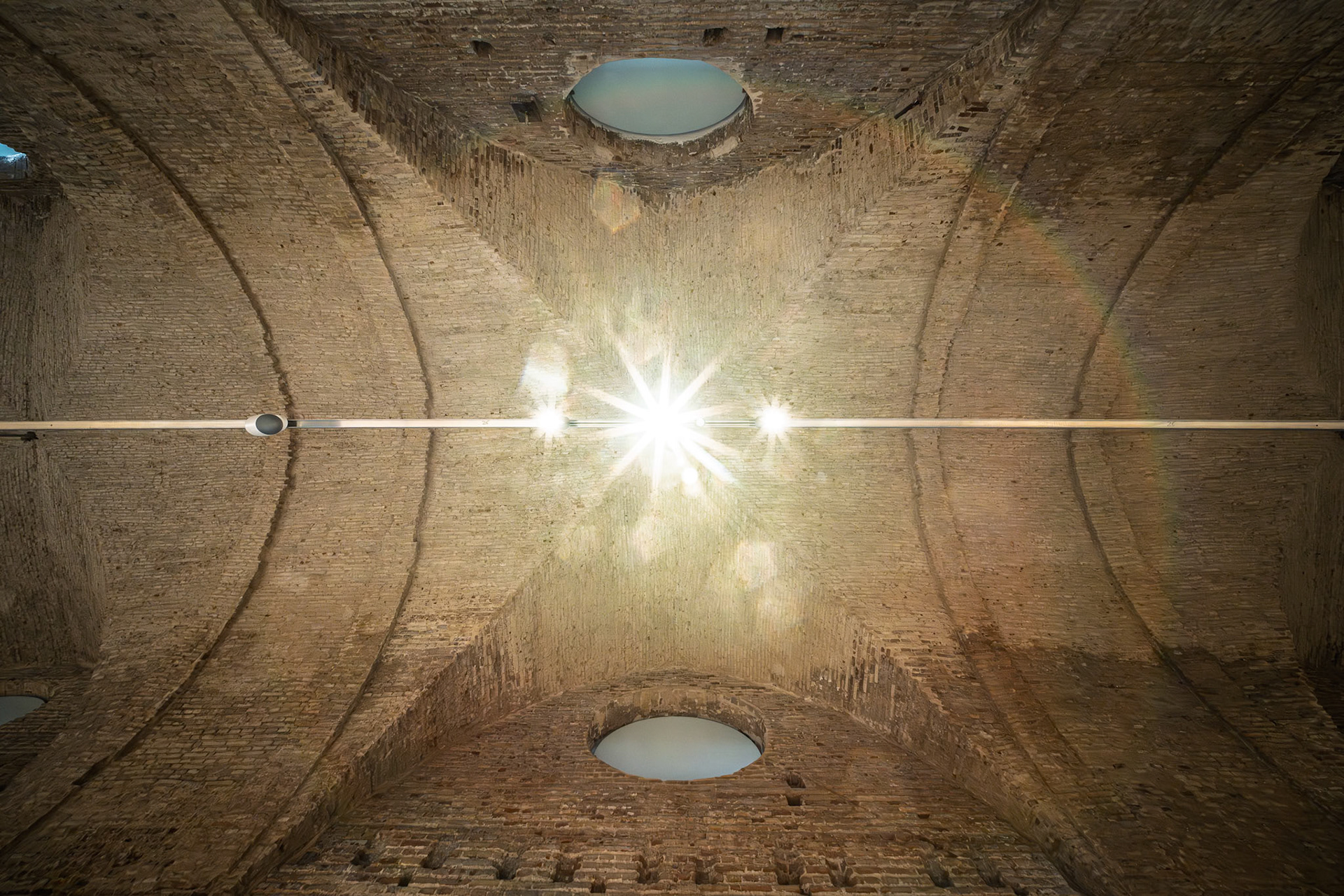 Seville's Atarazanas has a restored 13th-century brick ceiling with barrel vaults and circular windows, highlighting medieval architecture.