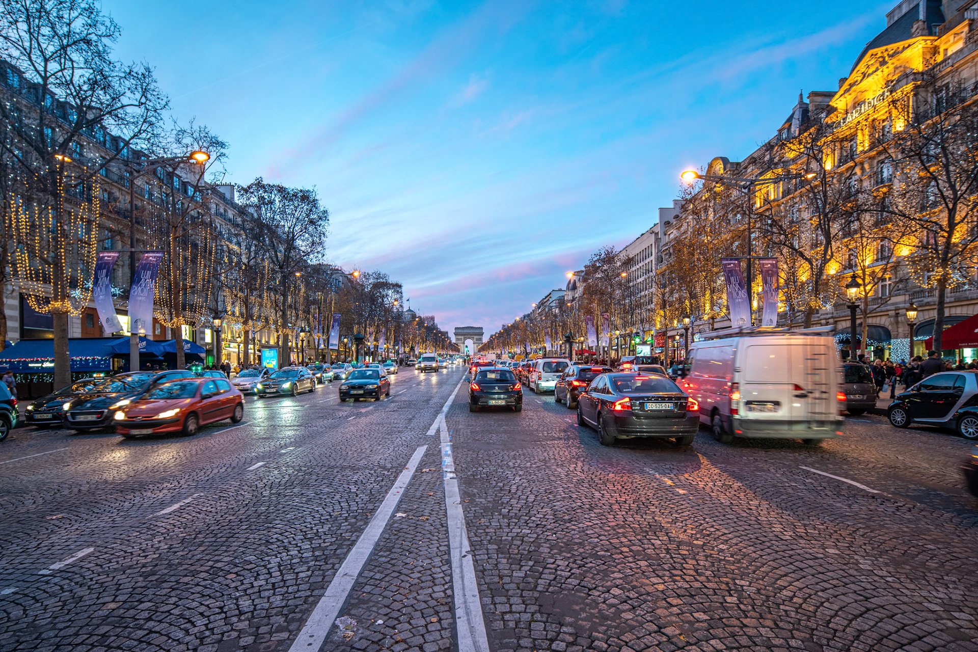 the festive illumination along the Champs-Élysées at dusk.