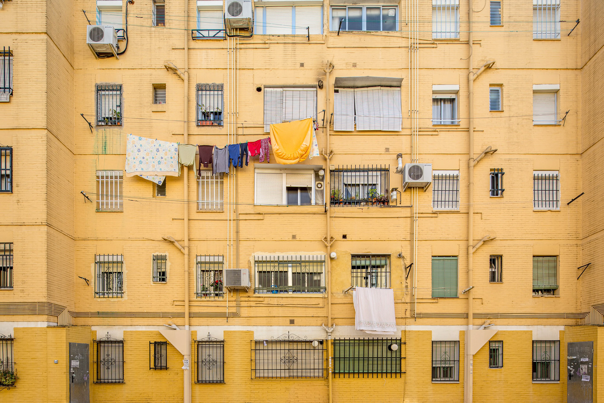 In Seville's Virgen de los Reyes neighborhood, barred windows and laundry-filled balconies showcase local life.