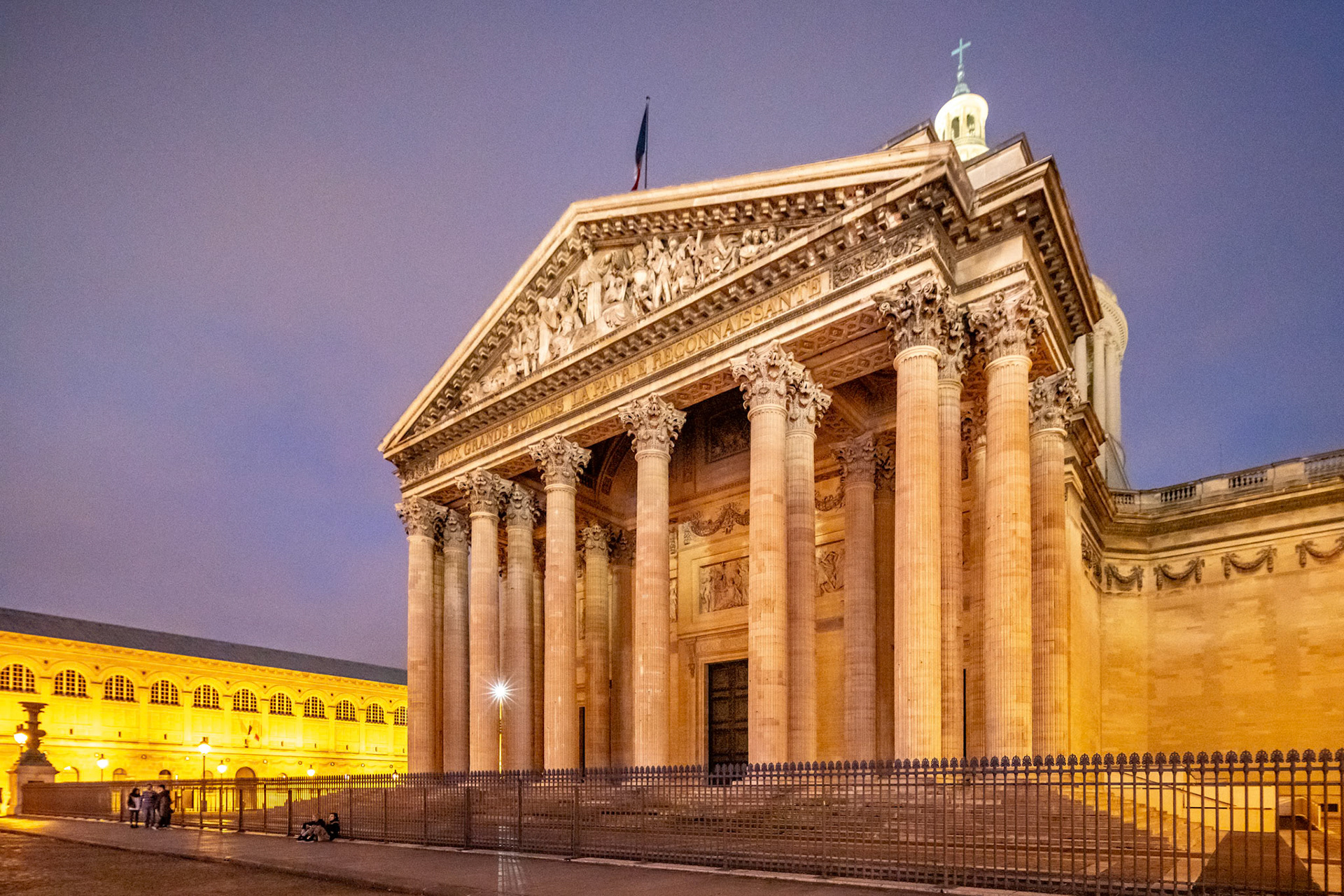 The Panthéon's neoclassical facade stands illuminated at dusk.