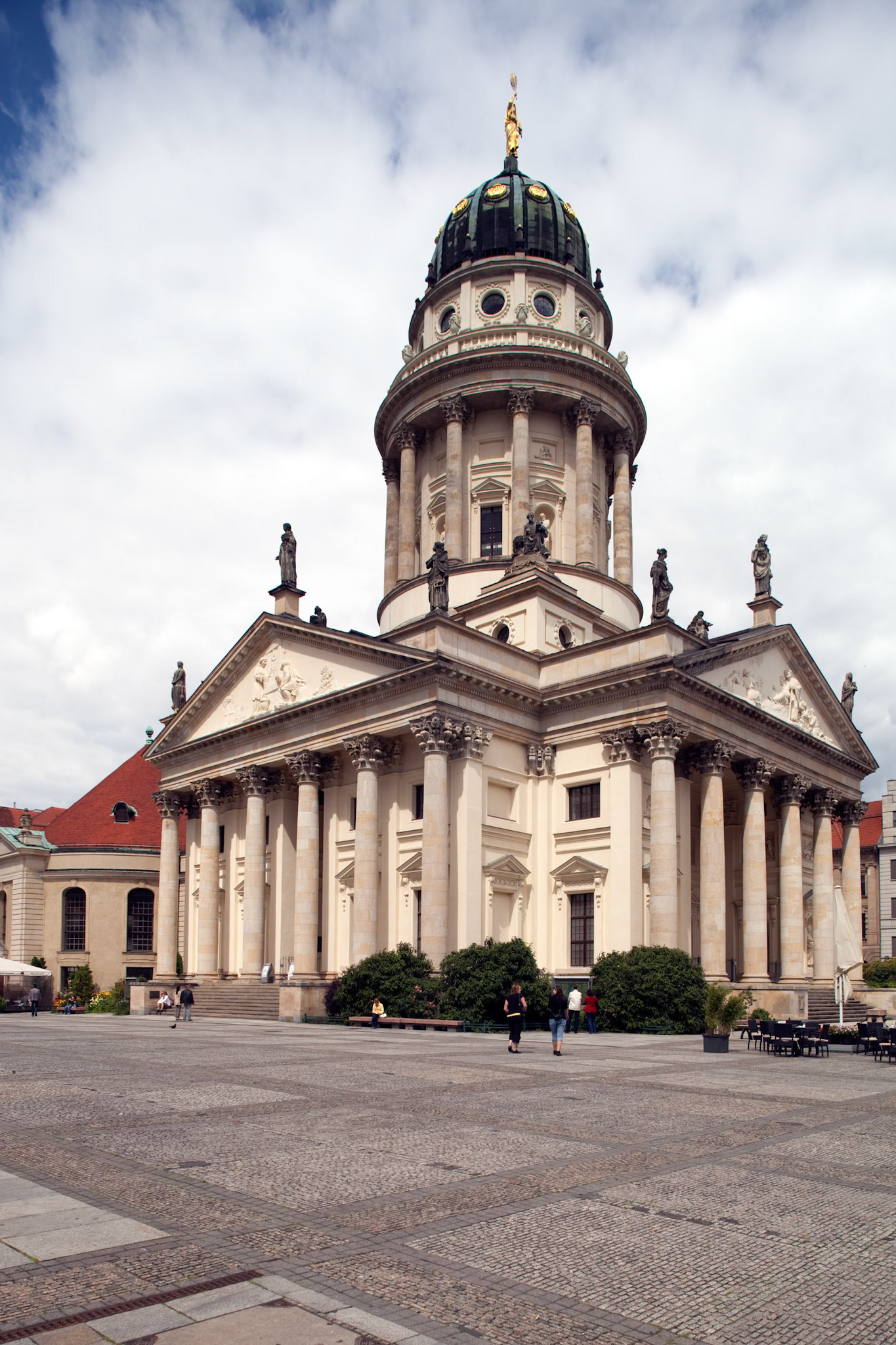 The iconic Französische Dom stands majestically in Gendarmenmarkt, surrounded by vibrant activity in the heart of Berlin.