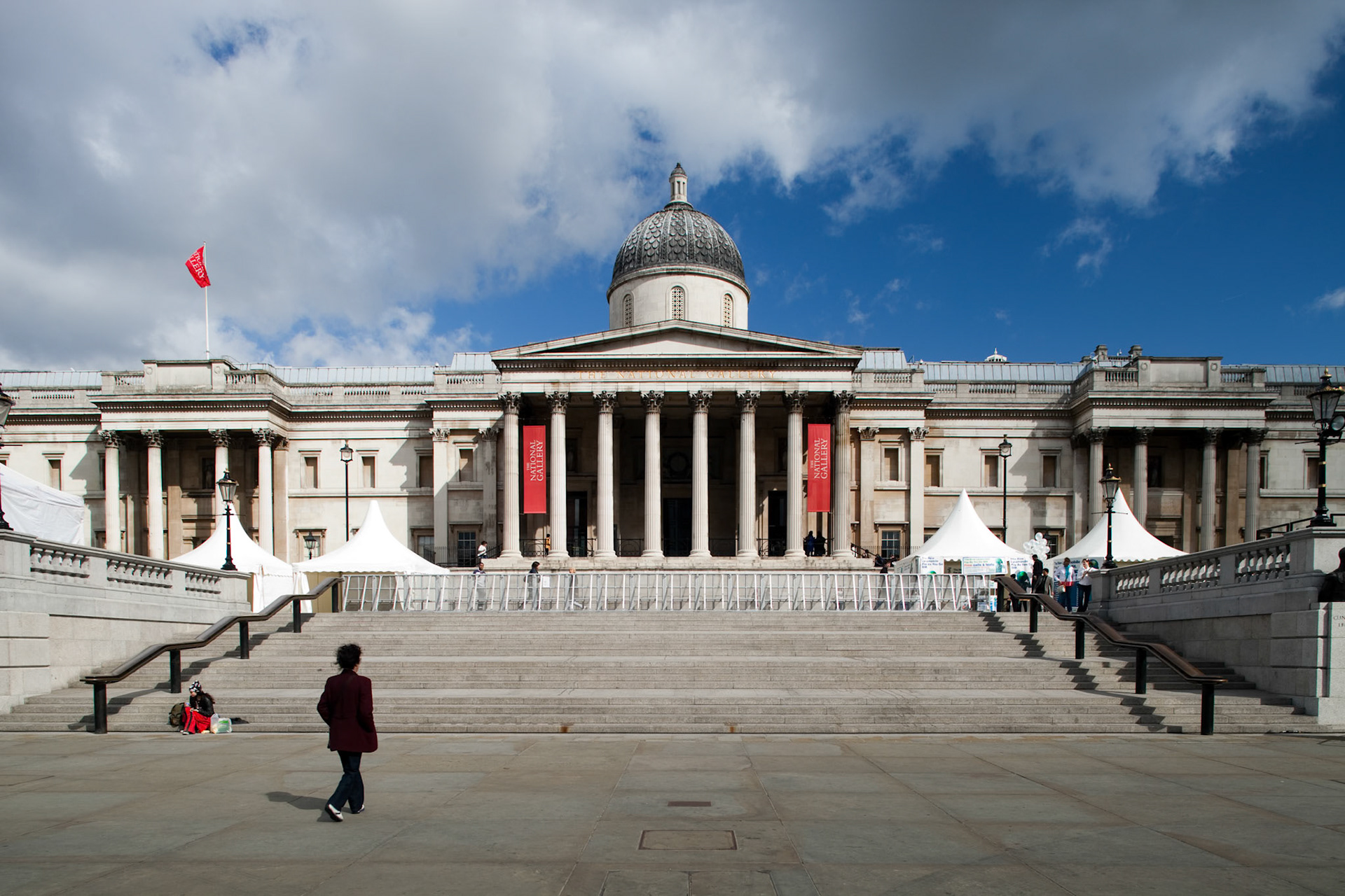 London, UK, May 3 2009, A visitor strolls past the grand steps of the National Gallery on a clear day in Trafalgar Square, showcasing its architectural beauty.