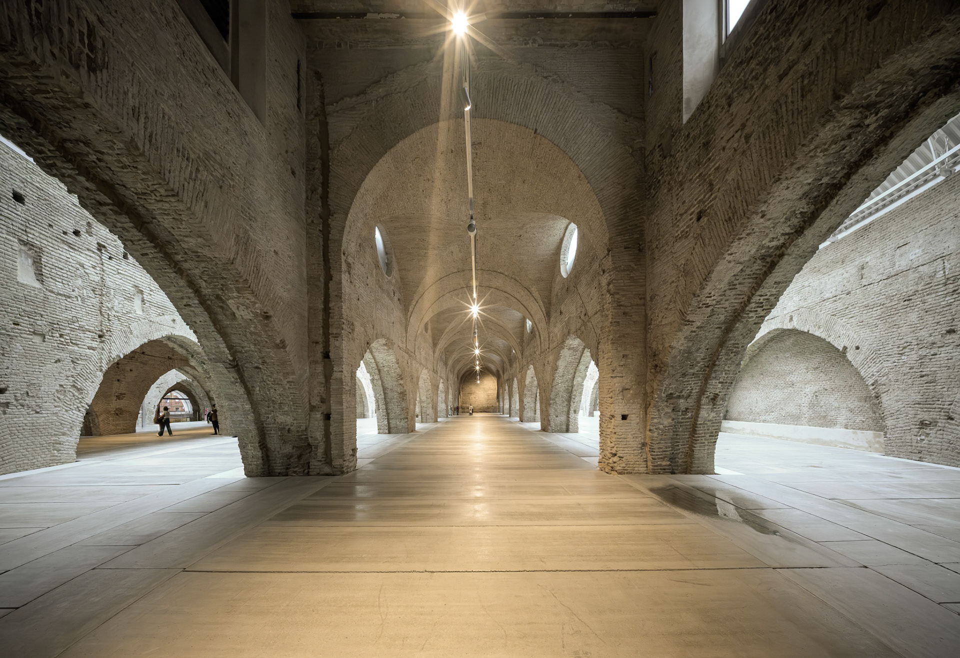 Seville's Atarazanas showcases restored medieval brick vaults with skylights, reflecting the shipyard's 13th-century heritage in Andalusia, Spain.