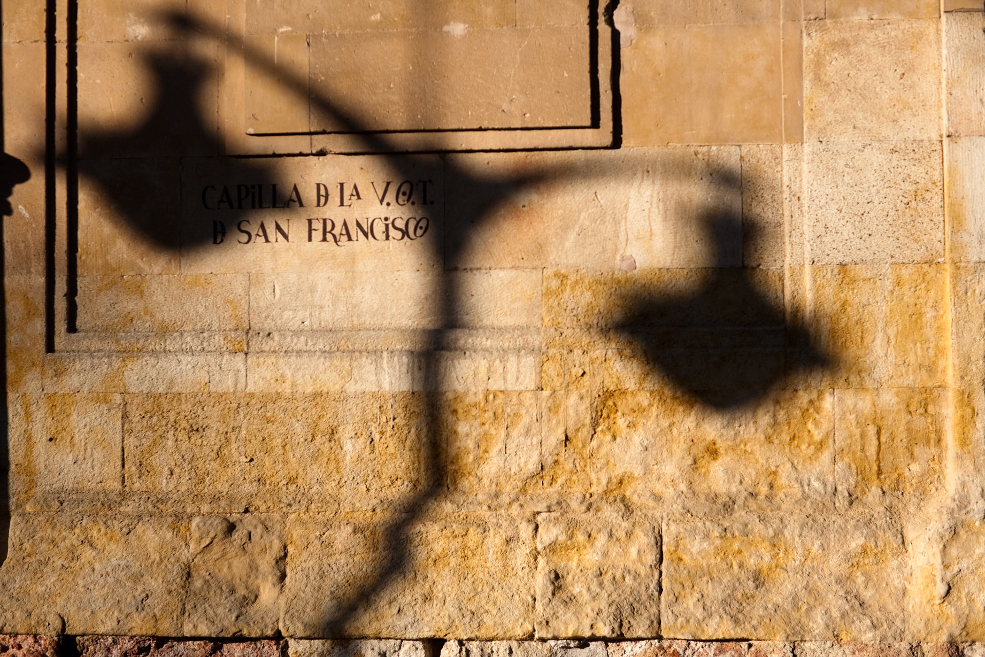 A streetlamp casts its shadow on the beautiful wall of the San Francisco church in Salamanca, creating an interesting visual effect.