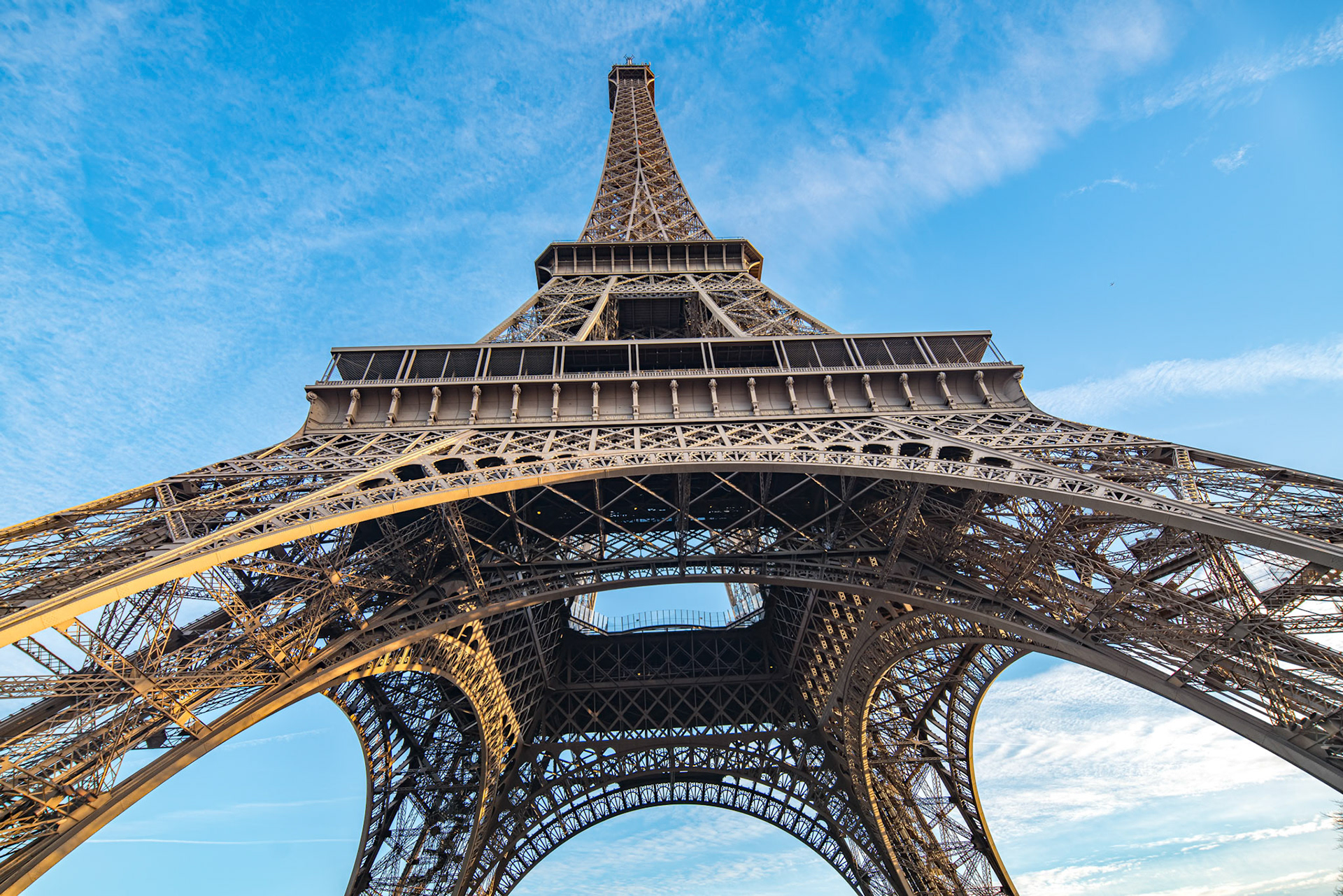 The Eiffel Tower stands tall against the blue sky in Paris.