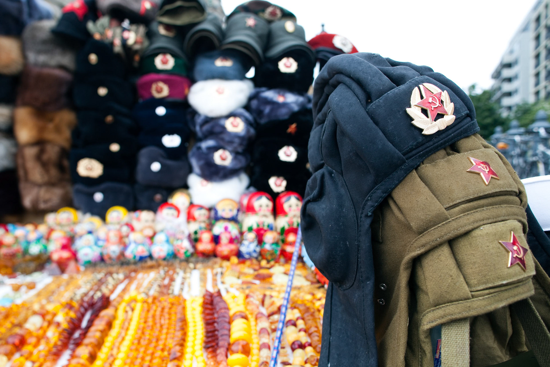 Souvenir stall in Berlin showcases memorabilia from the DDR and USSR, attracting tourists and locals alike with unique historical items.