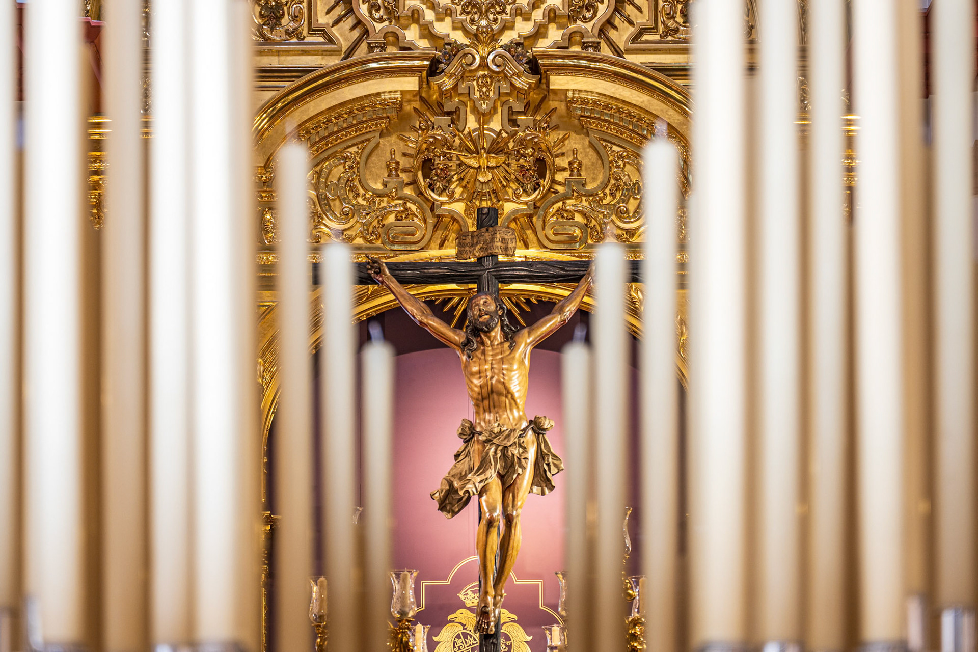 Cristo de la Expiración (El Cachorro) statue glimpsed through the candles of the Virgin of Patrocinio's palio float, Seville Holy Week.
