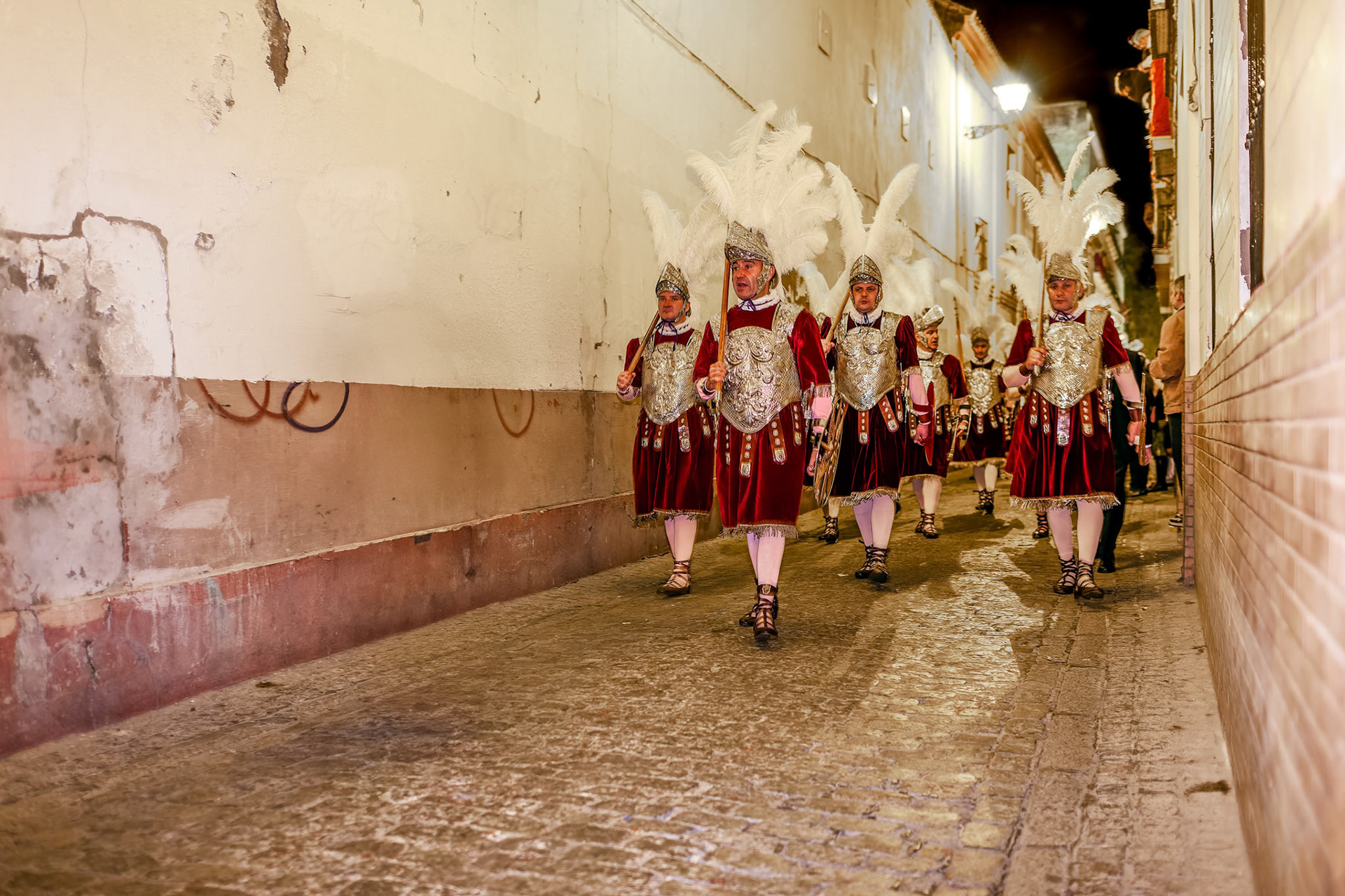 Seville, Spain, Apr 2 2010, Los Armaos, part of the Roman Centuria Macarena, march through a narrow street in Seville during the evening of Holy Thursday.