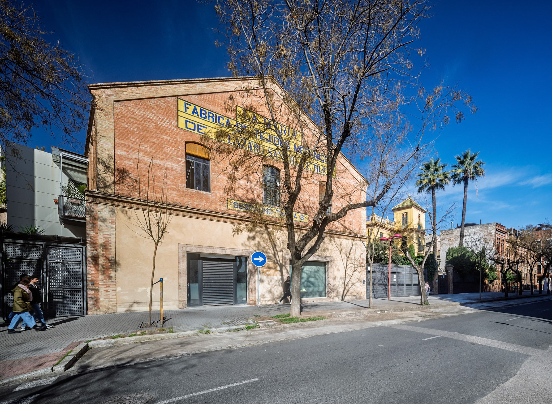 Urban view of Seville highlighting a historic residential building in bright sunlight.
