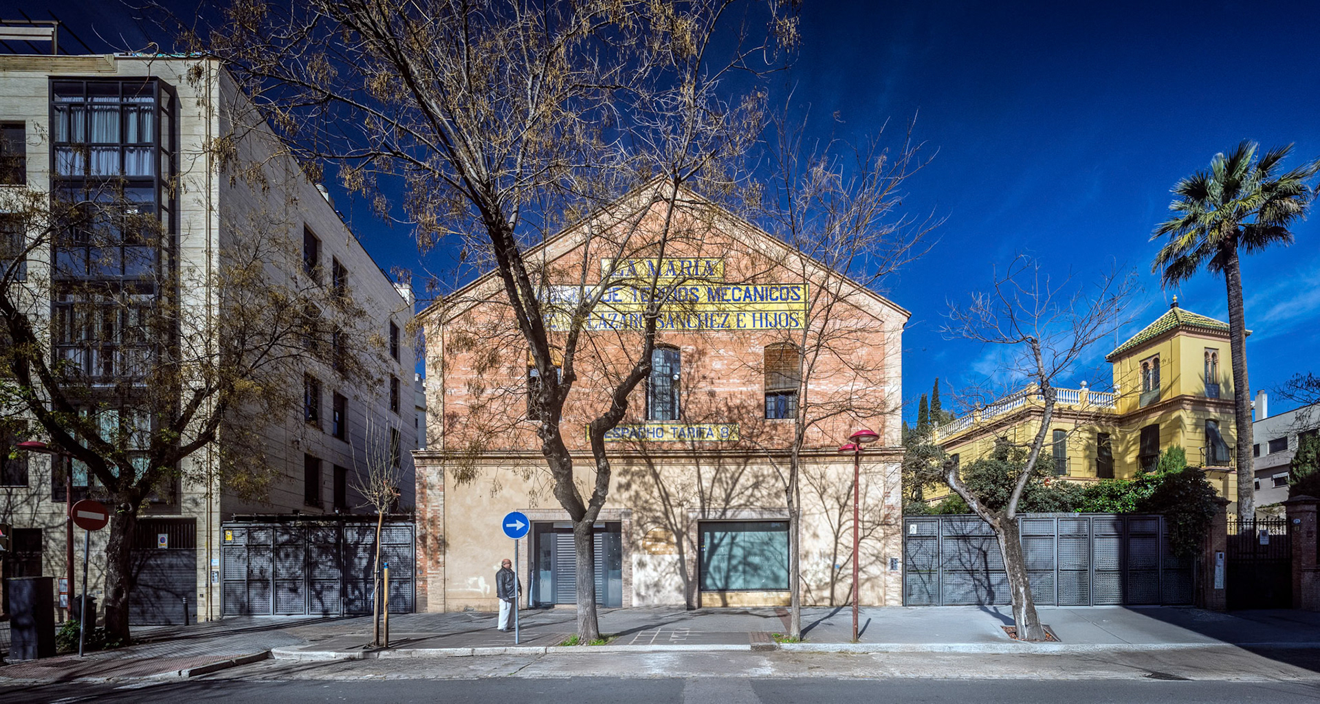 Urban view of Seville highlighting a historic residential building in bright sunlight.