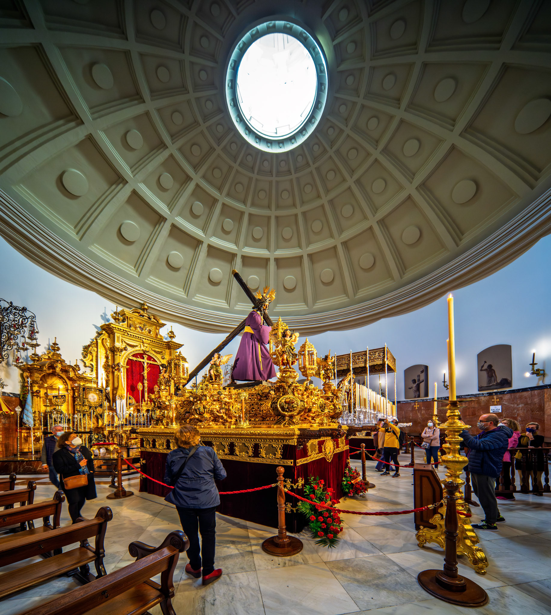 El Gran Poder paso prepared for Good Friday procession in Seville. Ornate float beneath the basilica's coffered dome and oculus during Holy Week.