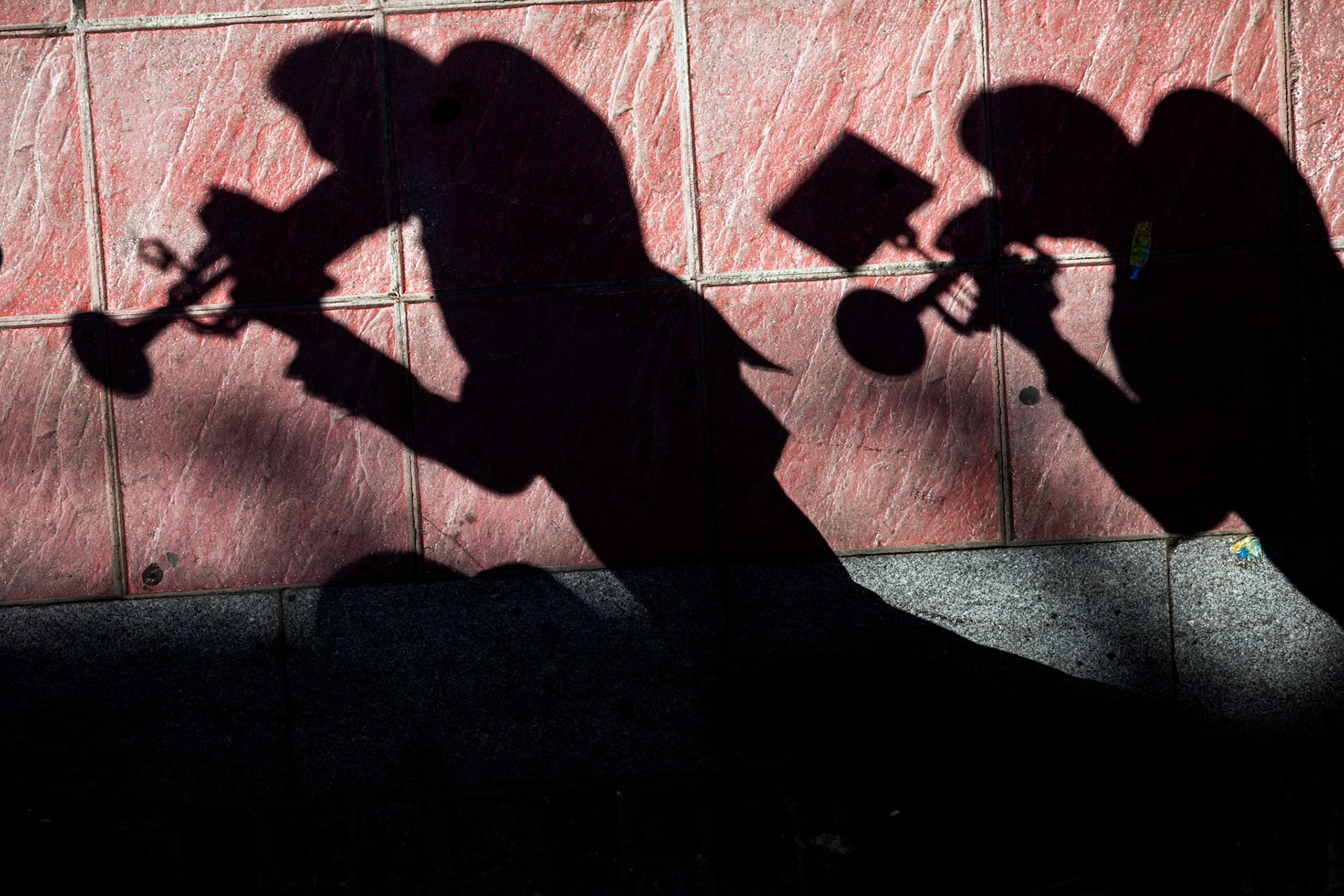 The shadow of musicians of a brass band, Seville, Spain