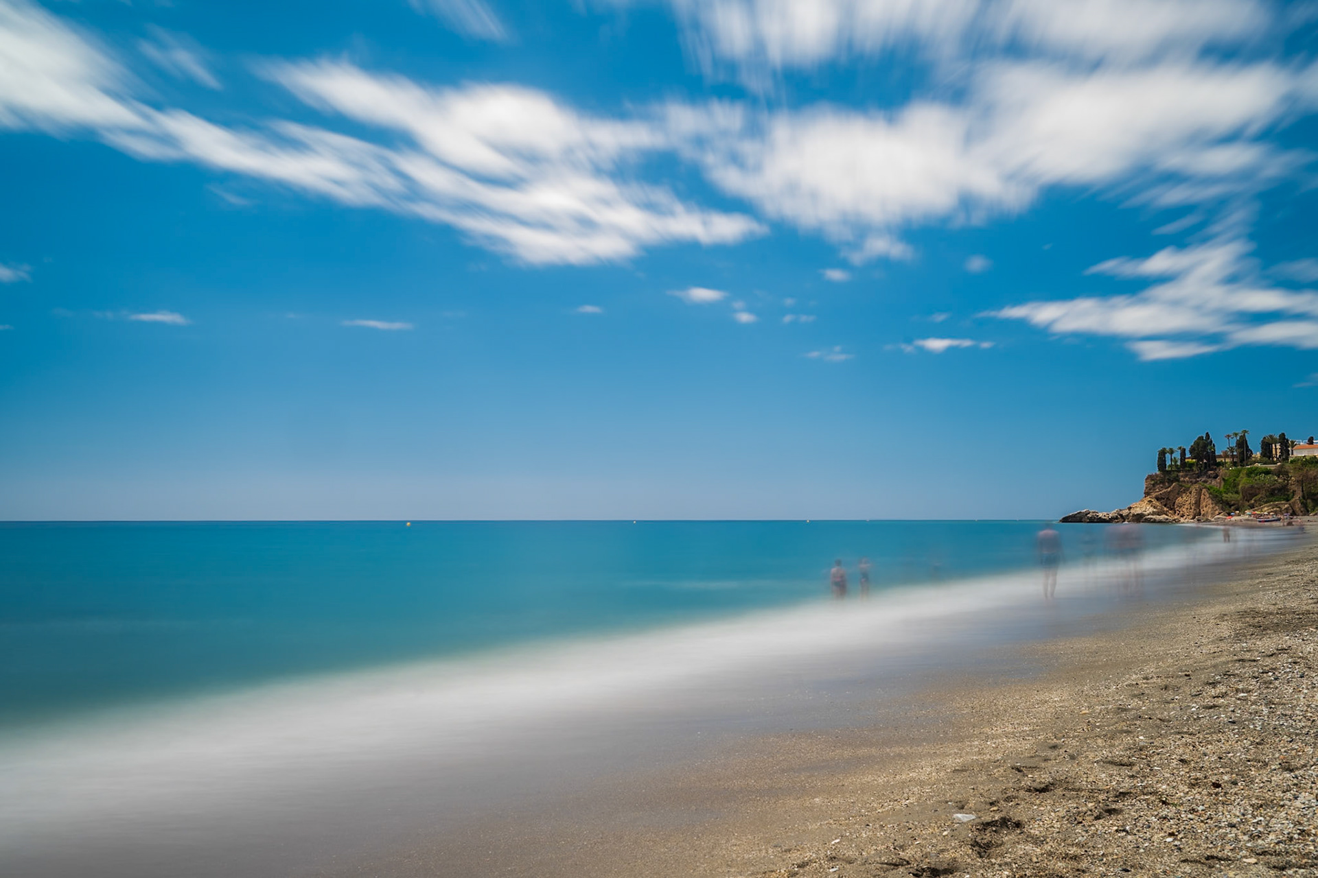 Long exposure photo of Burriana Beach, Nerja, showing a tranquil sea and coastline.
