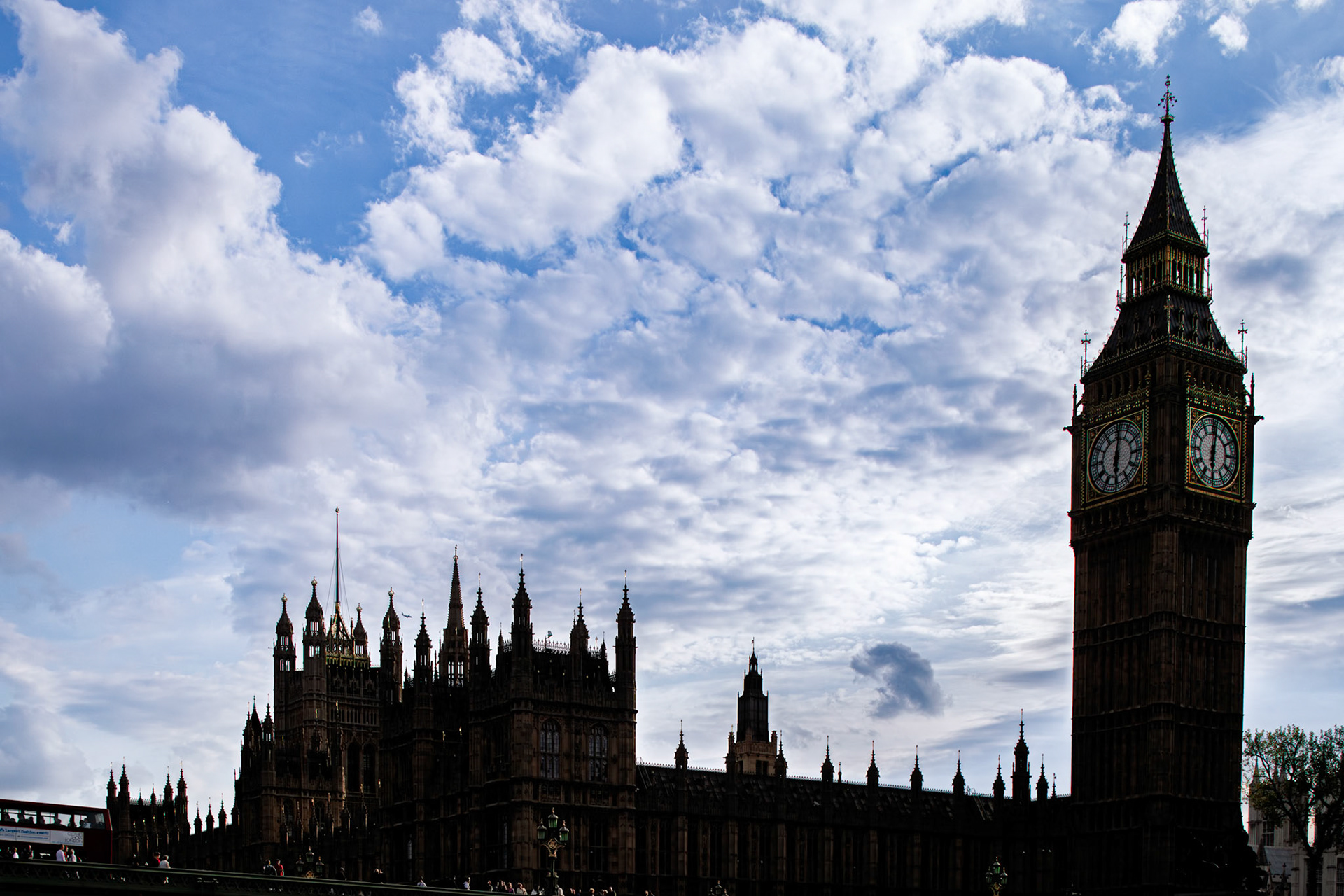 Big Ben stands tall against the cityscape as clouds drift in the evening sky over London. The iconic clock tower marks the time.