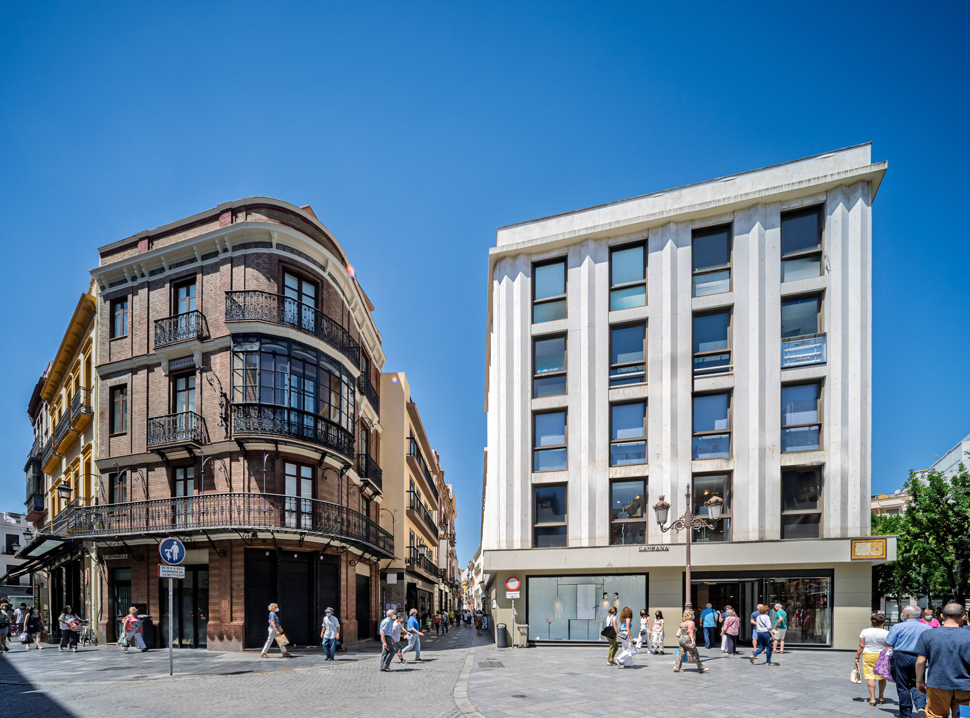 Seville, Spain, May 29 2021, Visitors stroll through Plaza de la Campana, surrounded by modern and classic buildings under a clear blue sky in bustling Seville, Spain.