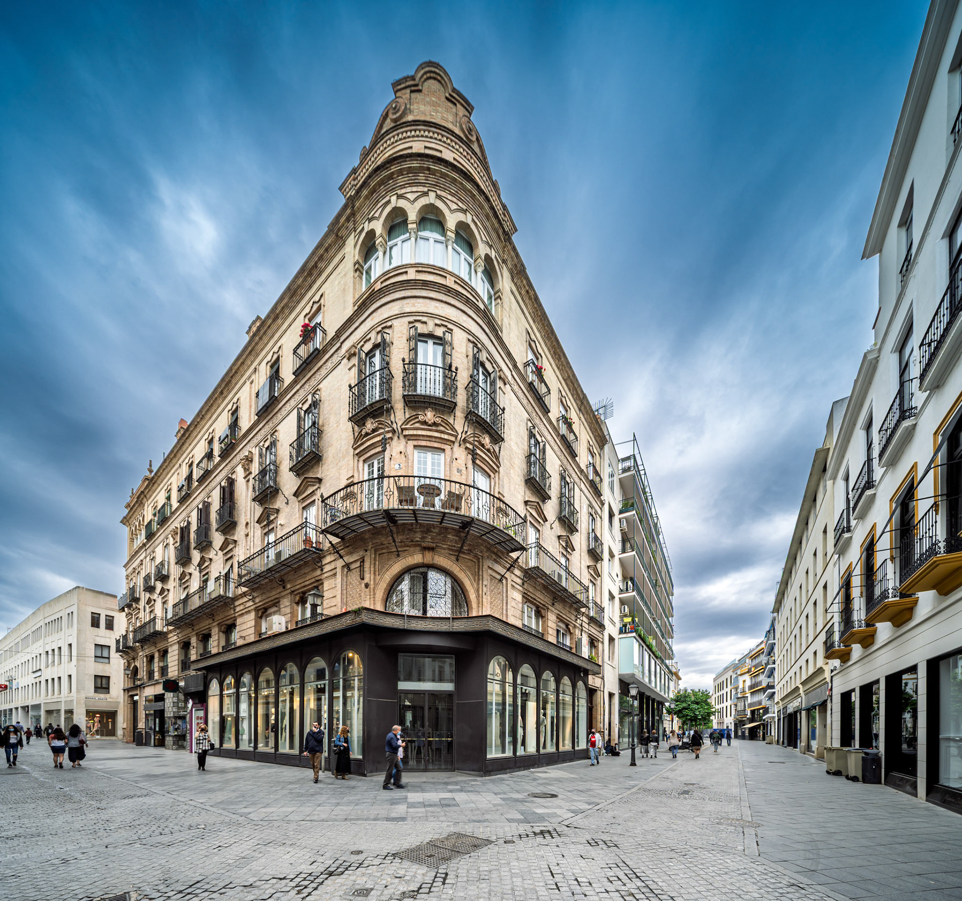 Sanchez Dalp House, designed by Anibal Gonzalez, stands prominently on Tetuan Street in Seville, showcasing unique architecture and lively activity.
