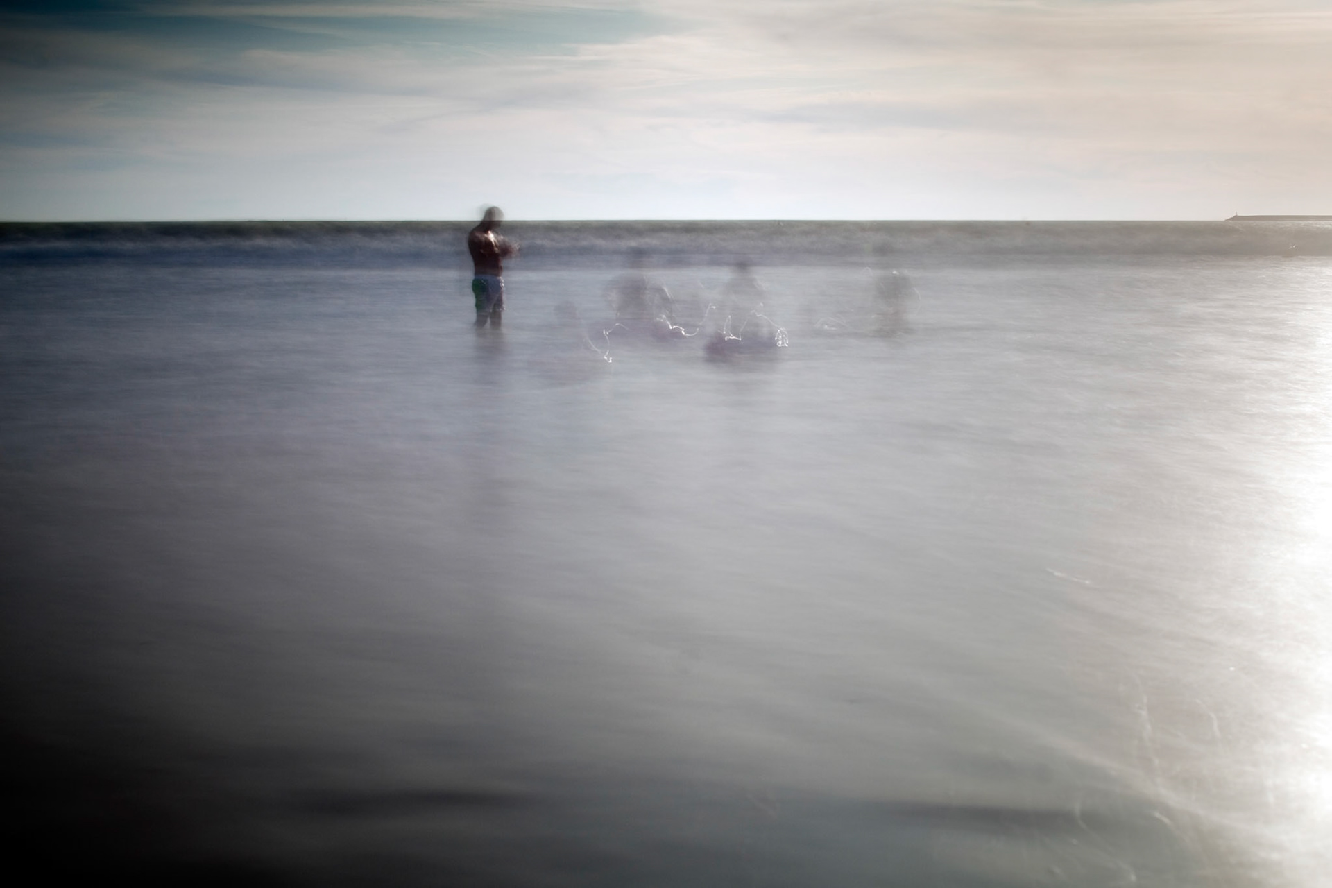 People bathing on the sea, Valdelagrana  beach, El Puerto de Santa Maria, Spain. Daylight long exposure shot by the use of neutral density filters.