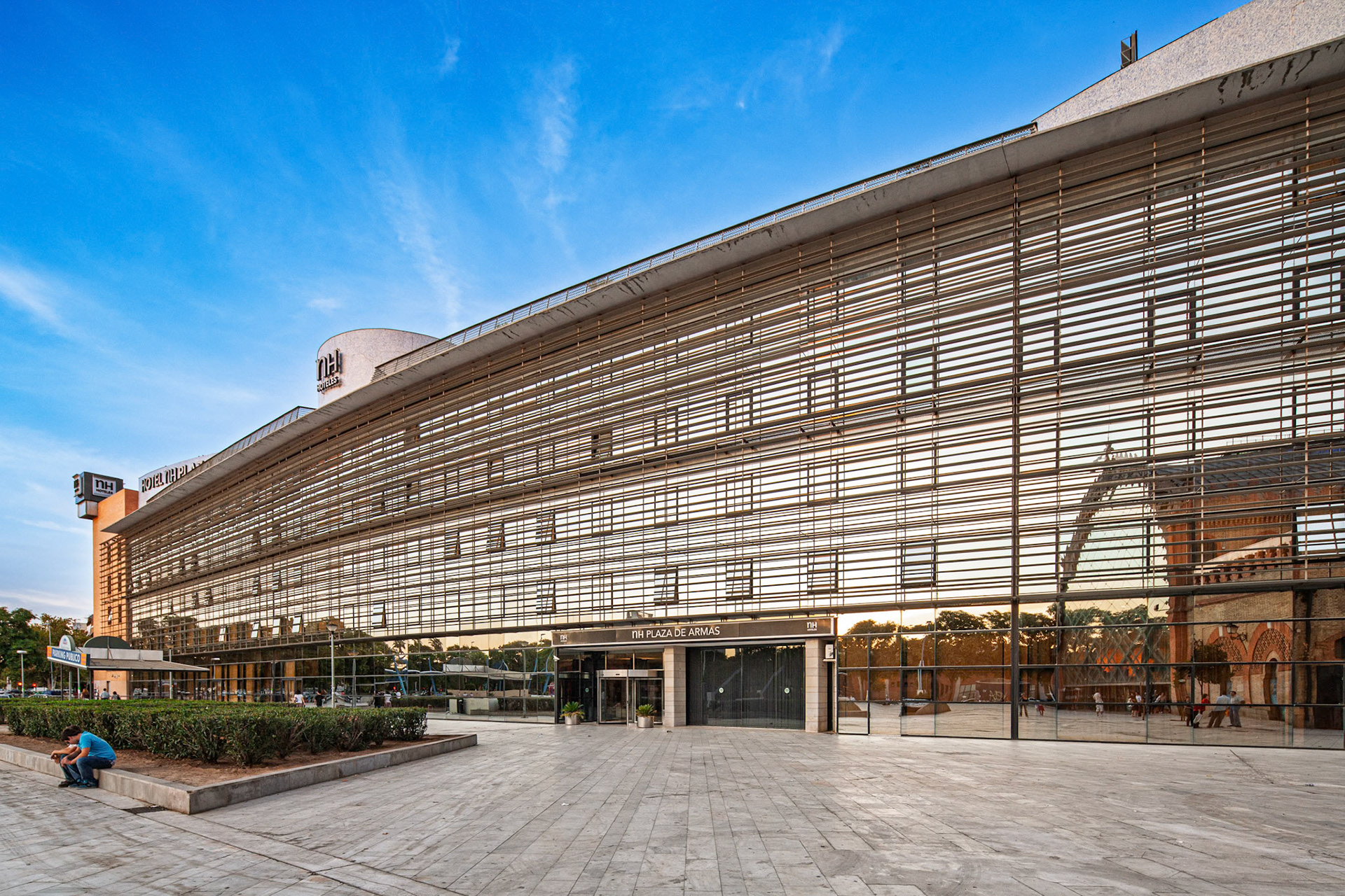 Gaze upon NH Plaza de Armas. A city centre hotel shows off stylish architecture and central location in Seville, Spain. Clean, Modern.
