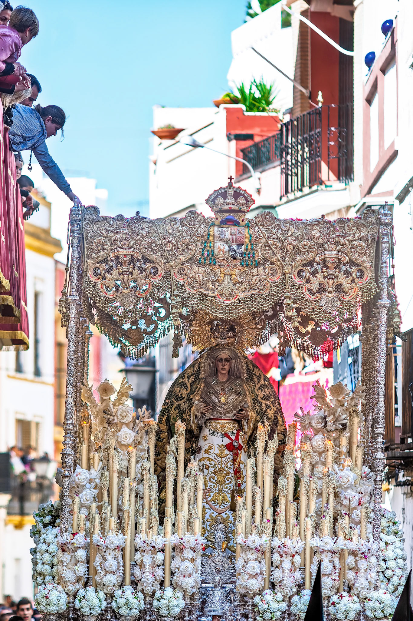 Seville, Spain, Apr 2 2010, On Good Friday morning in Seville, a girl extends her hand from a balcony to touch the canopy of the Esperanza Macarena.