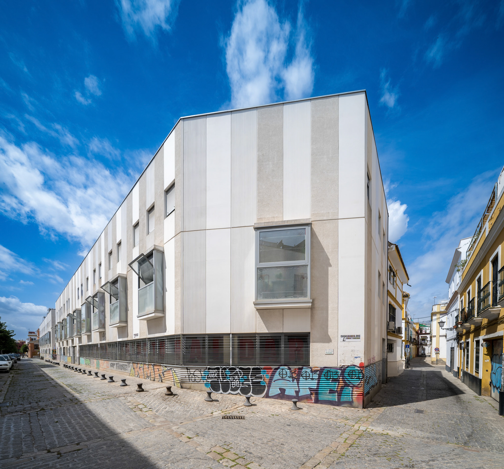 Urban social housing structure in Seville, Spain, surrounded by decorated city streets.