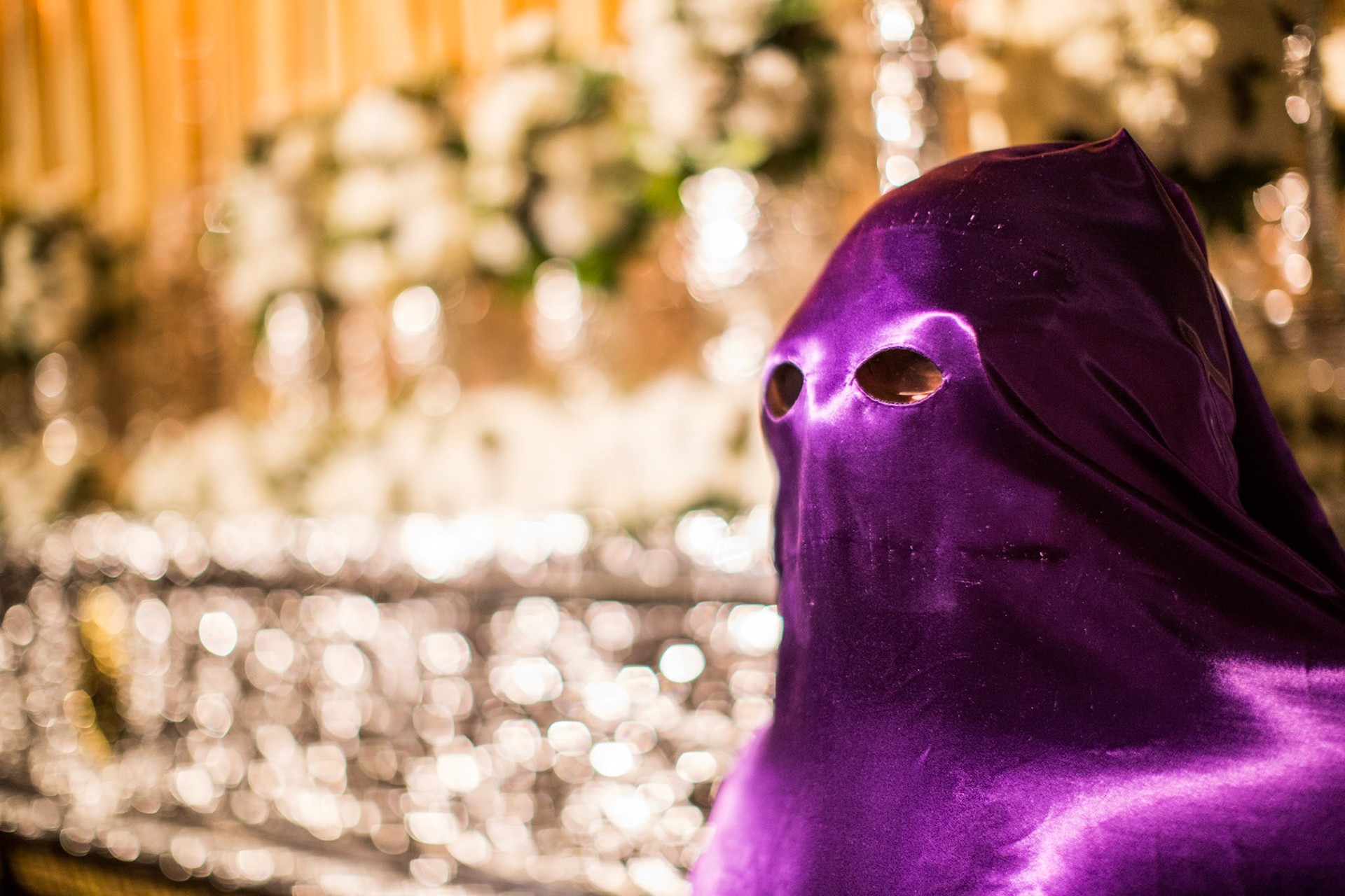 Hooded penitent in front of a Holy Week float