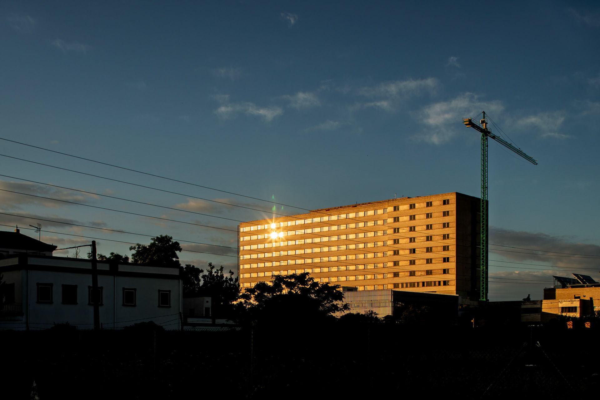 Historic Hospital Militar de Sevilla shines in the golden light at sunset, showcasing its architecture before recent renovations in Seville.