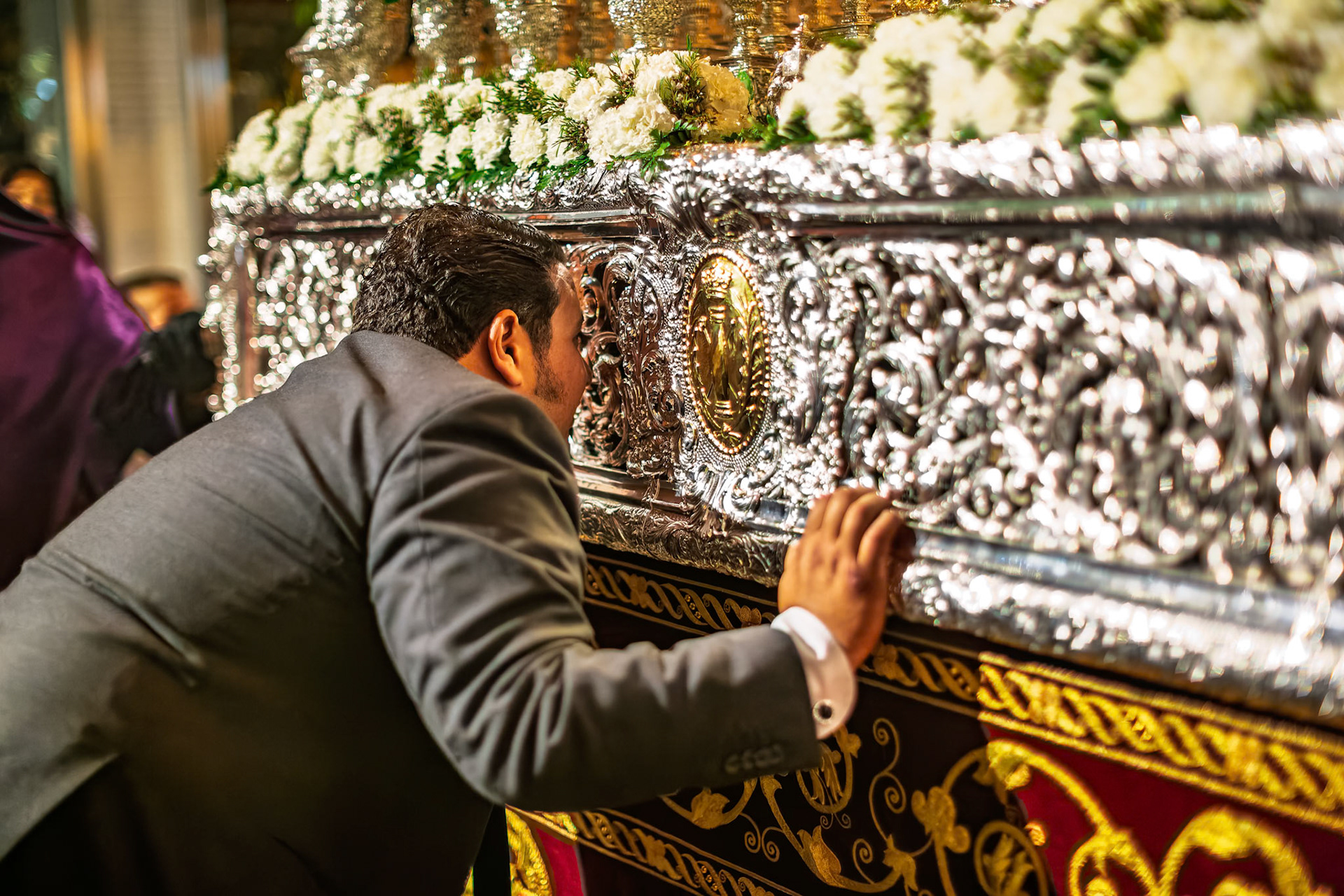 During Holy Week in Seville, the capataz of the Virgin of Victory directs costaleros before the ceremonial levantá beneath an ornate canopy.