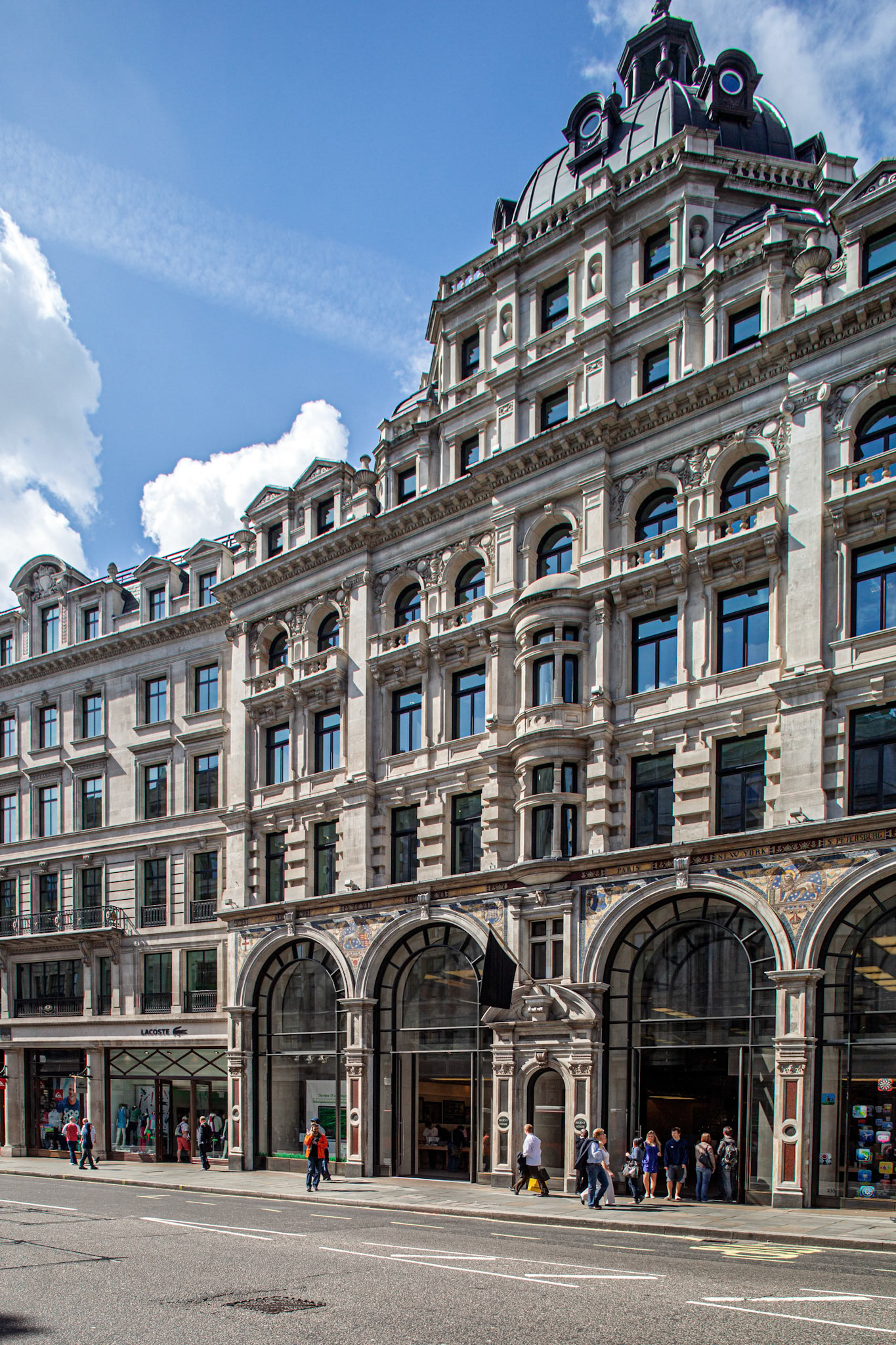 A large building on Regent Street features a domed roof and detailed designs. It was built in 1898 and is now a retail location.