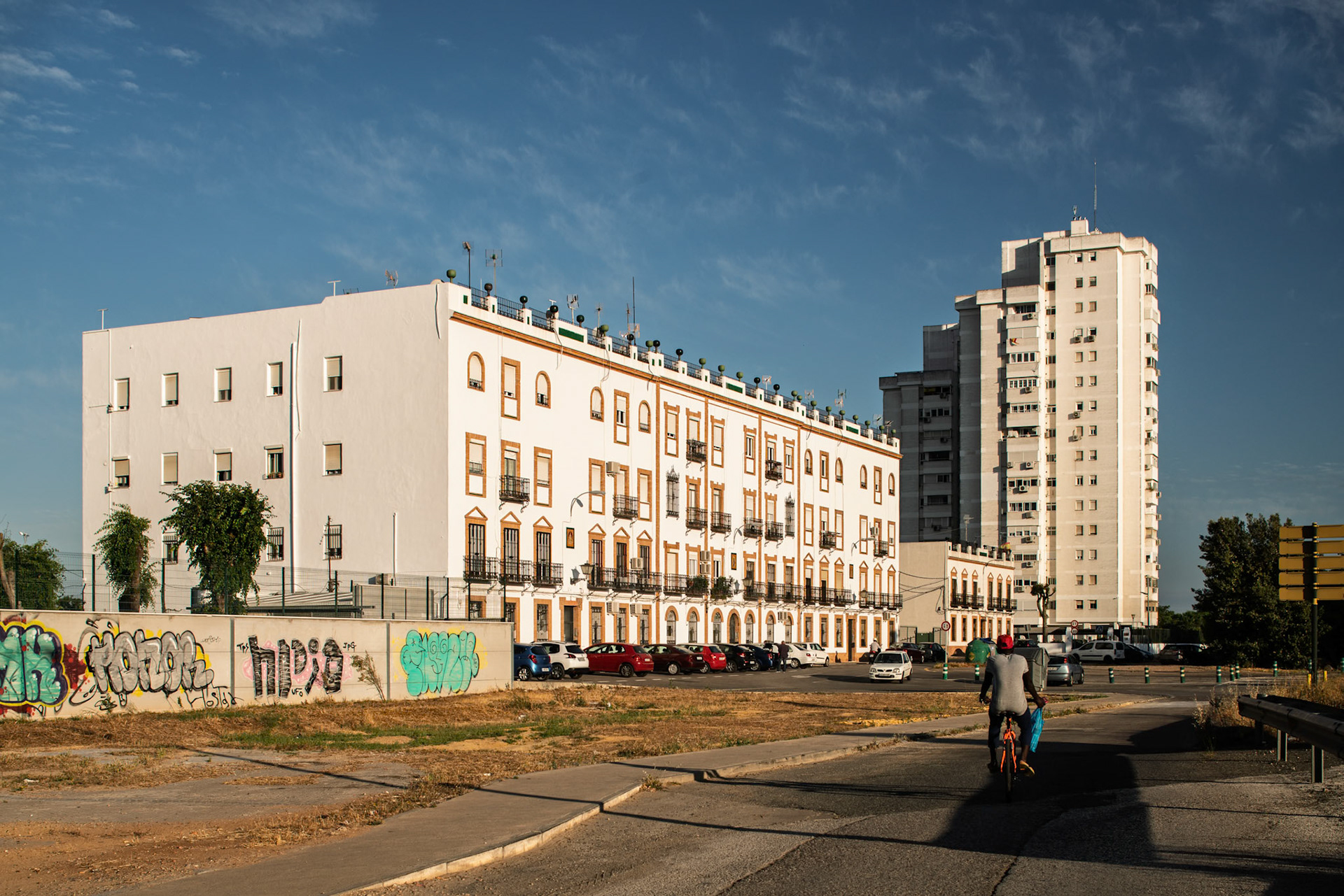 Mid-20th-century buildings alongside a taller structure in Seville's Pineda neighborhood highlight the area's architectural diversity.