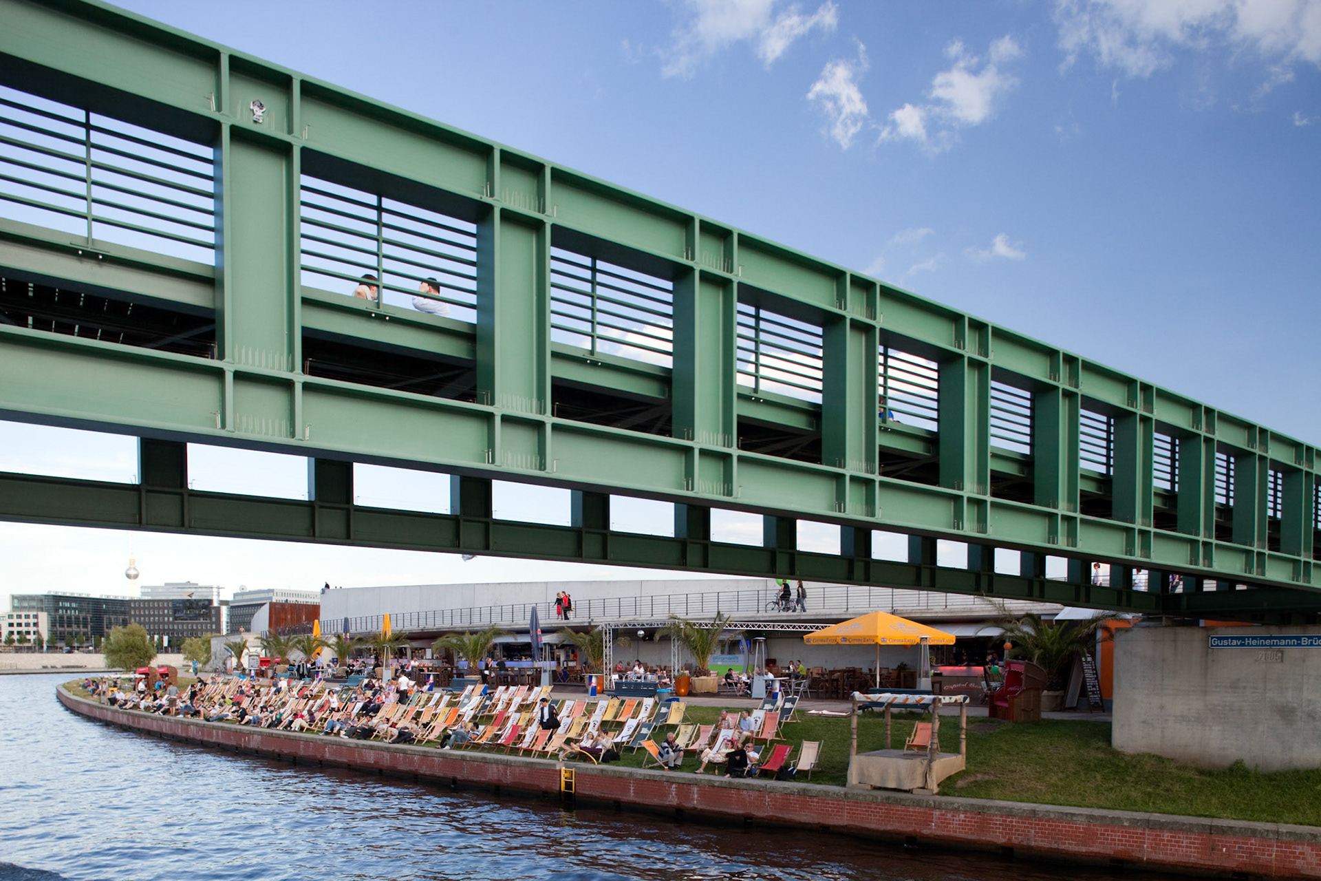 Berlin, Germany, July 27 2009, People relax on sunbeds along the Spree river beneath the Gustav-Heinemann bridge, enjoying a vibrant day in Berlin\'s Mitte district.