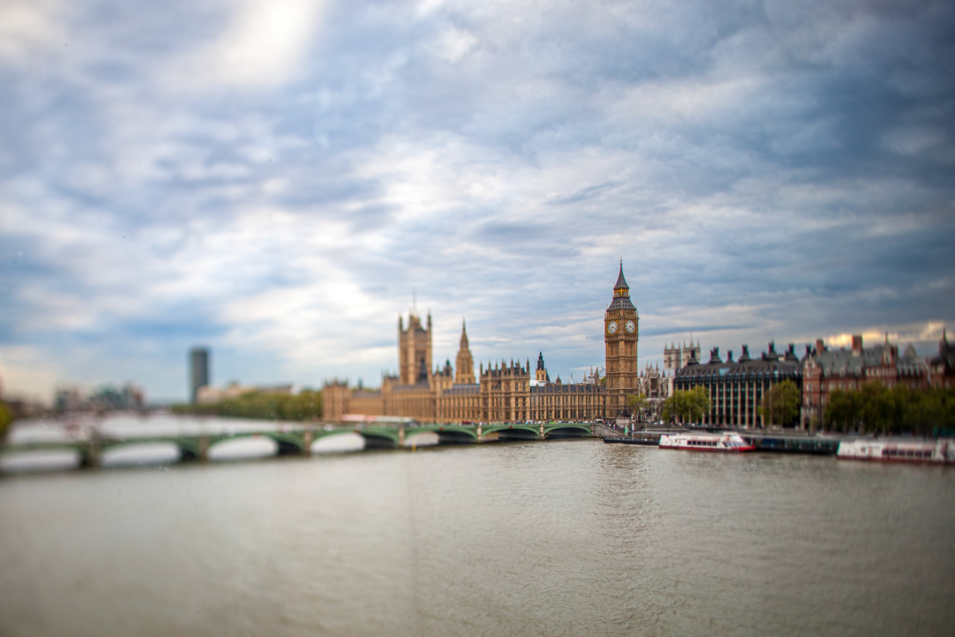 Westminster skyline with the Thames River in London, captured at dusk using a tilt-shift effect.